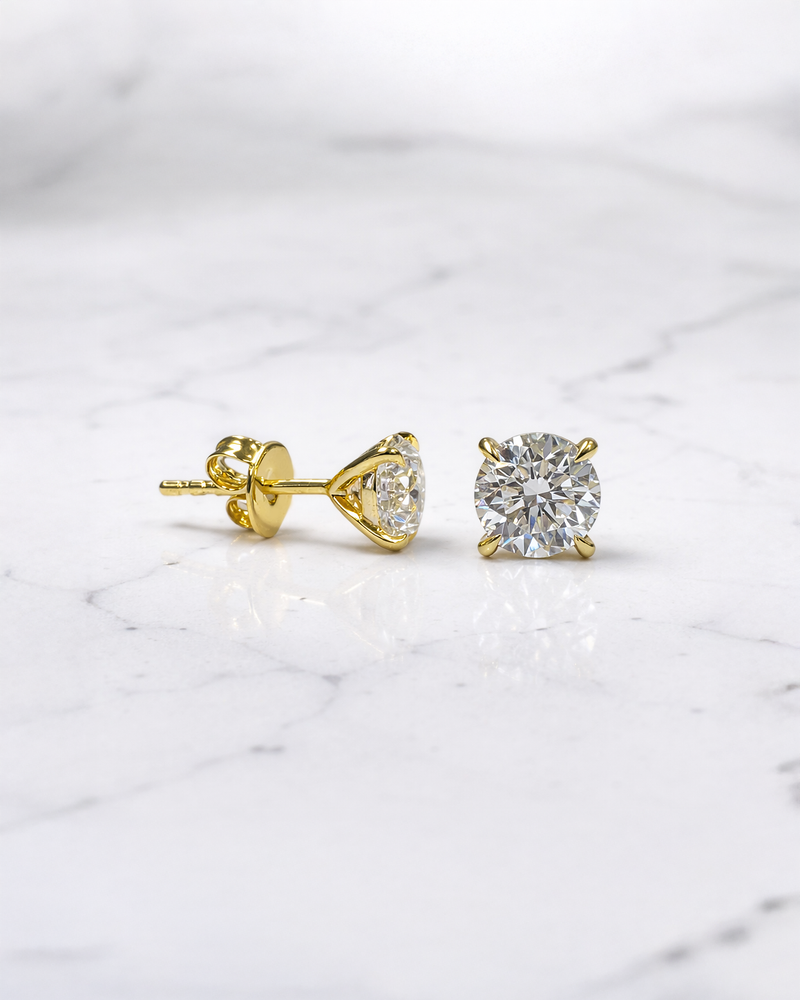 2ct total lab grown diamond stud earrings in martini setting on ear, round brilliant diamonds in yellow gold. Made in London