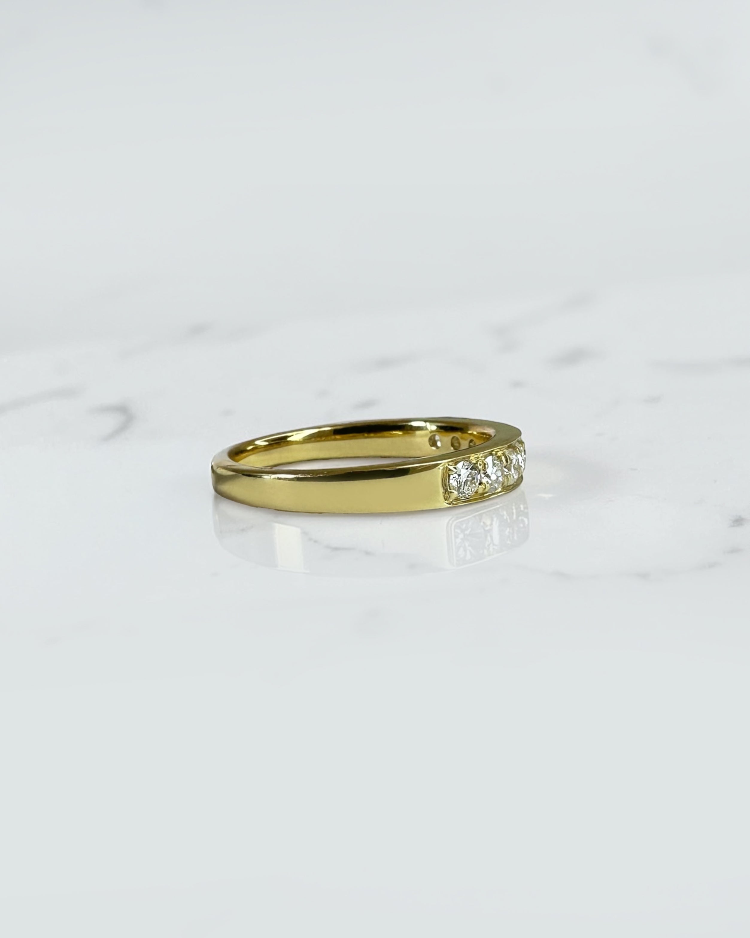 3.3mm yellow gold channel set round diamond wedding band with 0.45ct diamonds, available in lab grown or natural diamonds.