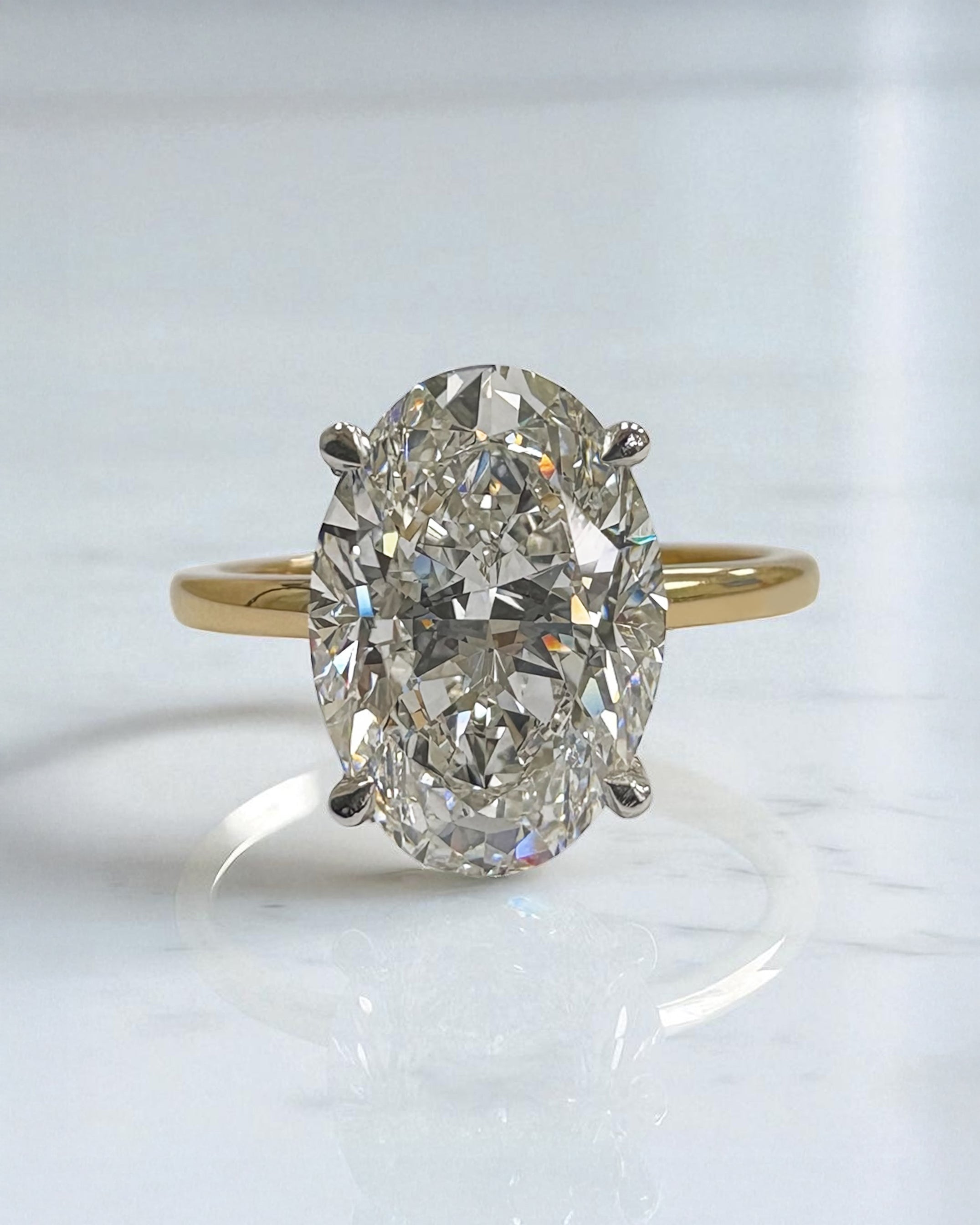 3.50ct oval cut lab grown diamond engagement ring with platinum head and hidden halo 18kt yellow gold