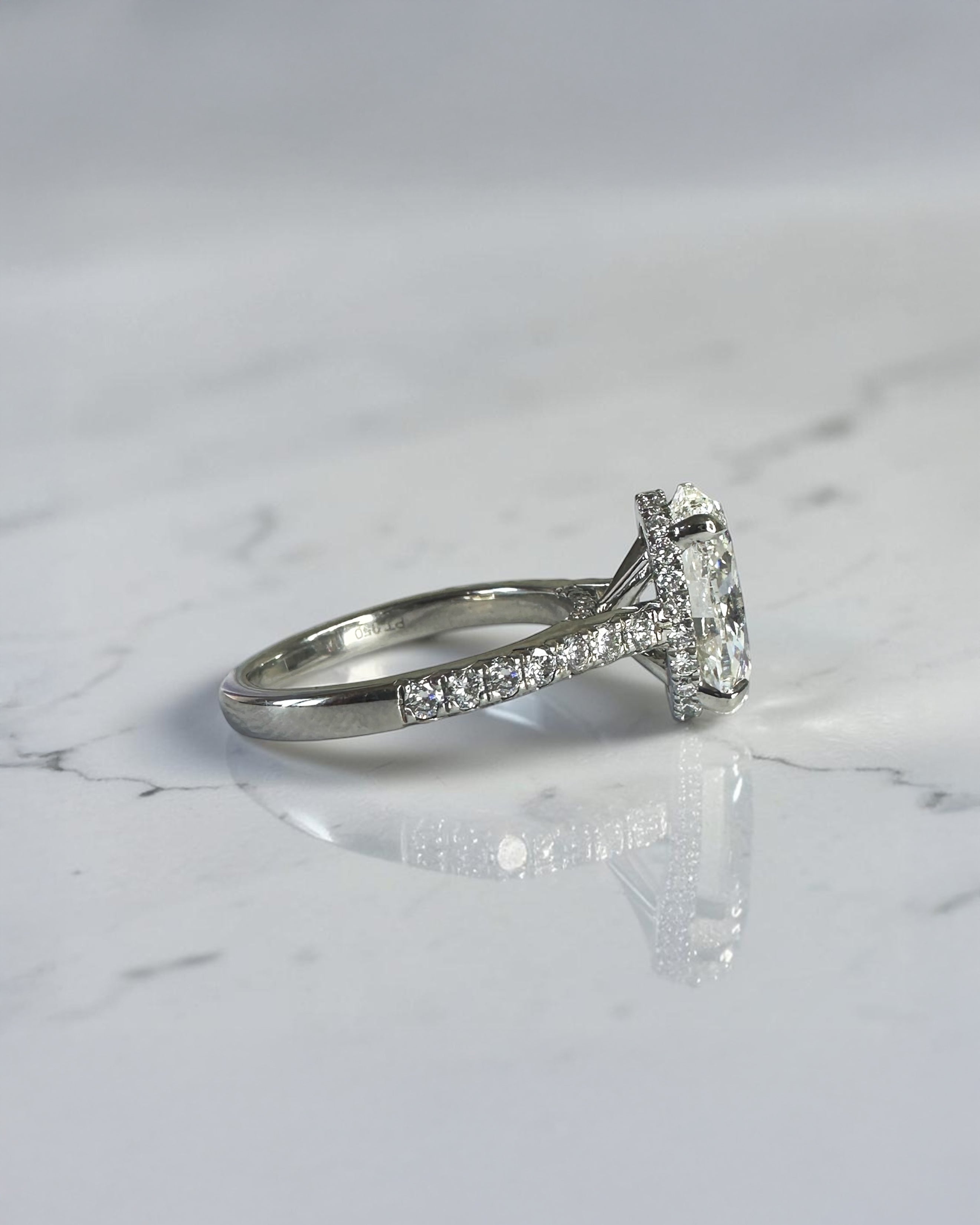 3.50ct oval cut lab grown diamond cathedral hidden halo engagement ring with diamond set shoulders and diamond bridge in platinum
