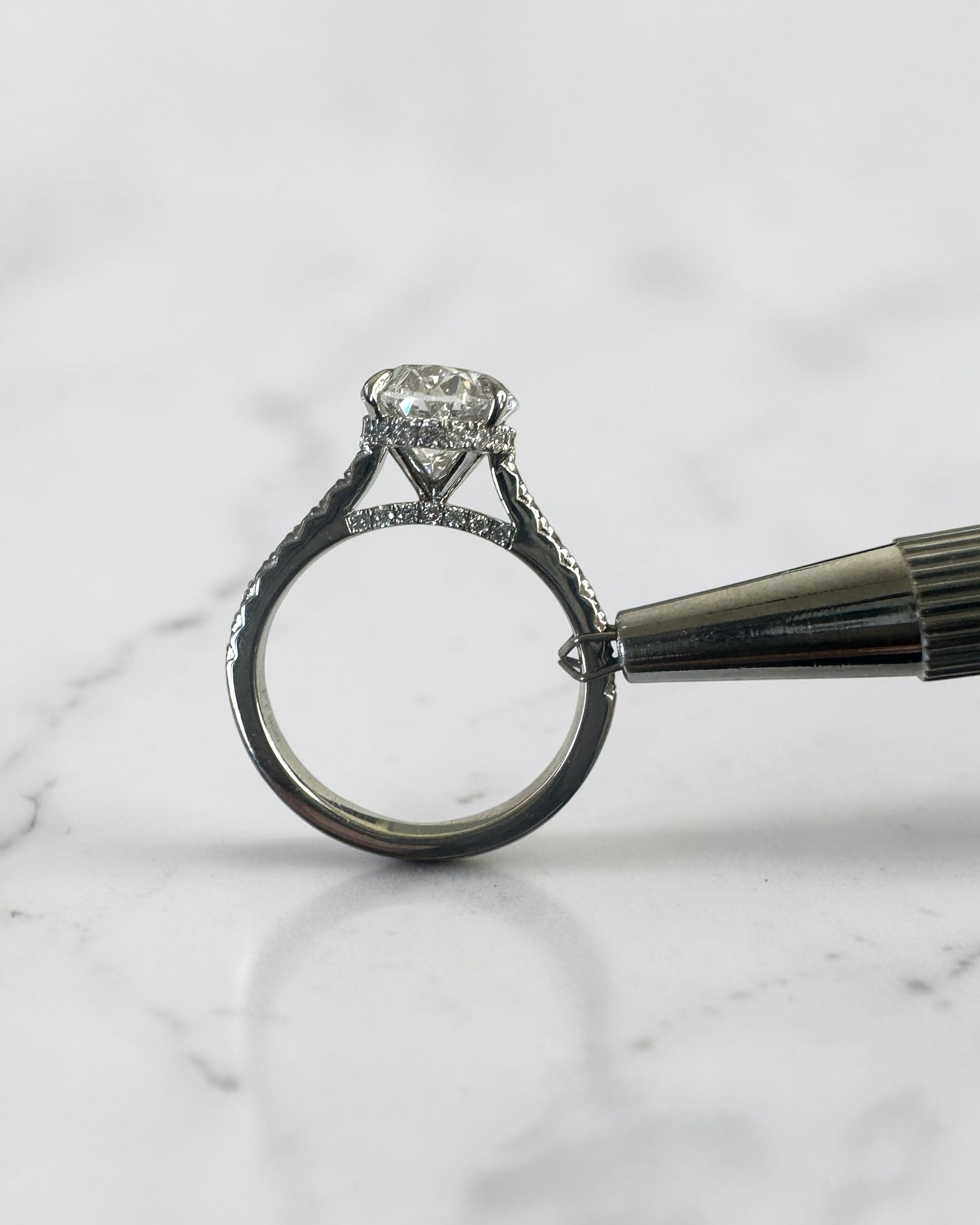 3.50ct oval cut lab grown diamond cathedral hidden halo engagement ring with diamond set shoulders and diamond bridge in platinum
