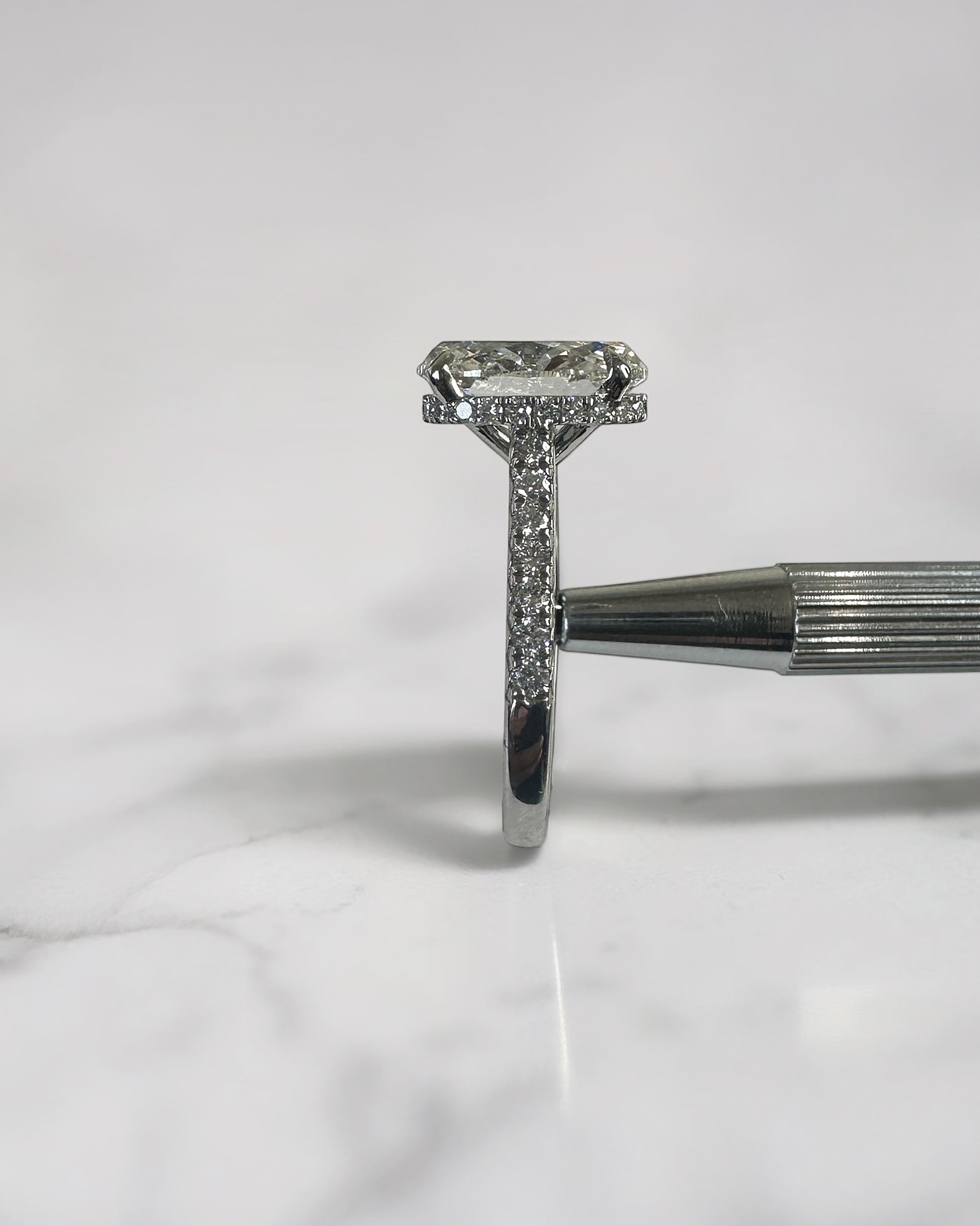 3.50ct oval cut lab grown diamond cathedral hidden halo engagement ring with diamond set shoulders and diamond bridge in platinum
