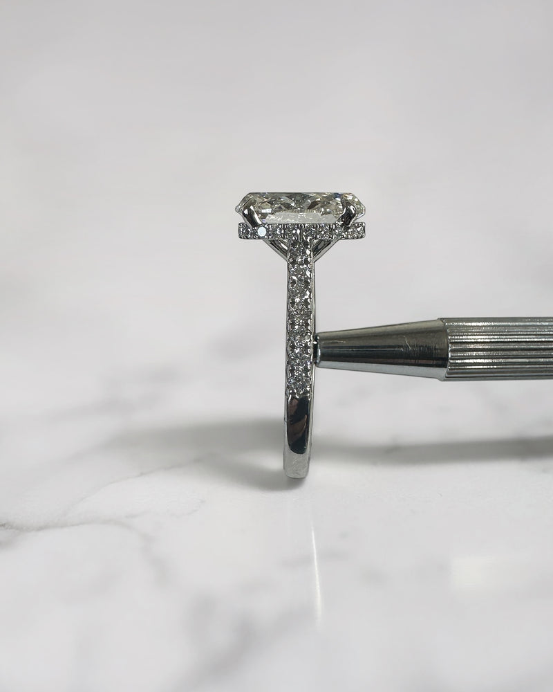 3.50ct oval cut lab grown diamond cathedral hidden halo engagement ring with diamond set shoulders and diamond bridge in platinum
