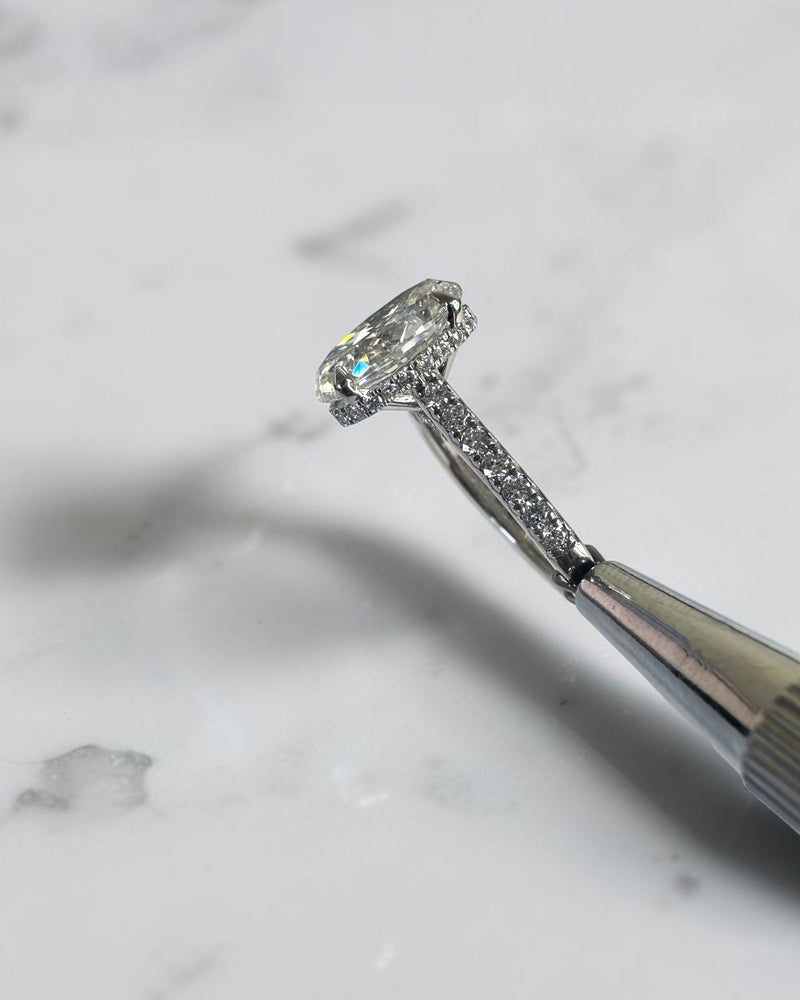3.50ct oval cut lab grown diamond cathedral hidden halo engagement ring with diamond set shoulders and diamond bridge in platinum

