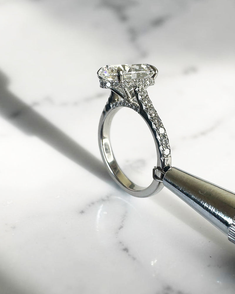 3.50ct oval cut lab grown diamond cathedral hidden halo engagement ring with diamond set shoulders and diamond bridge in platinum
