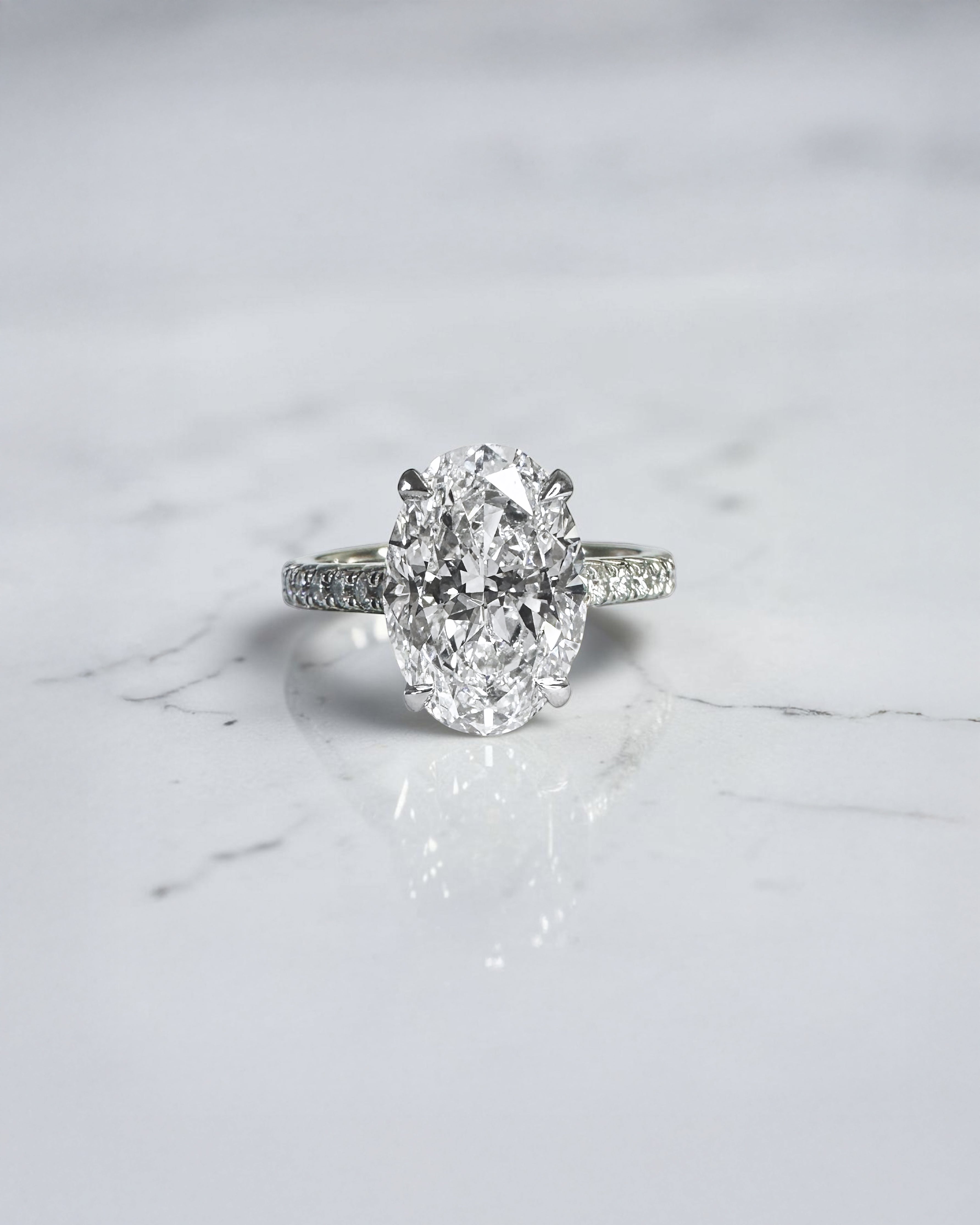 3.50ct oval cut lab grown diamond cathedral hidden halo engagement ring with diamond set shoulders and diamond bridge in platinum