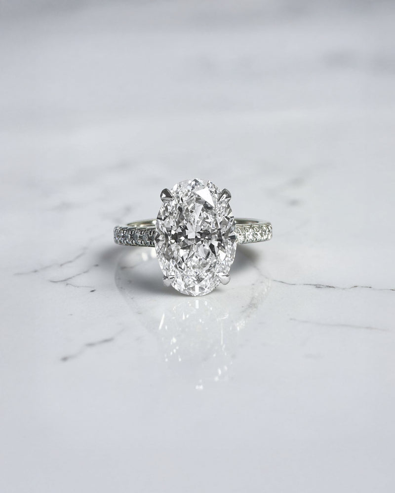 3.50ct oval cut lab grown diamond cathedral hidden halo engagement ring with diamond set shoulders and diamond bridge in platinum