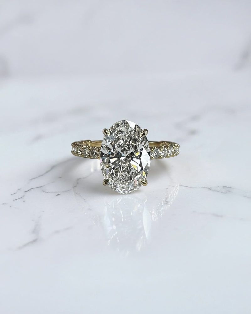 3.50ct oval cut lab grown diamond engagement ring with U prong floating setting and diamond set shoulders in yellow gold
