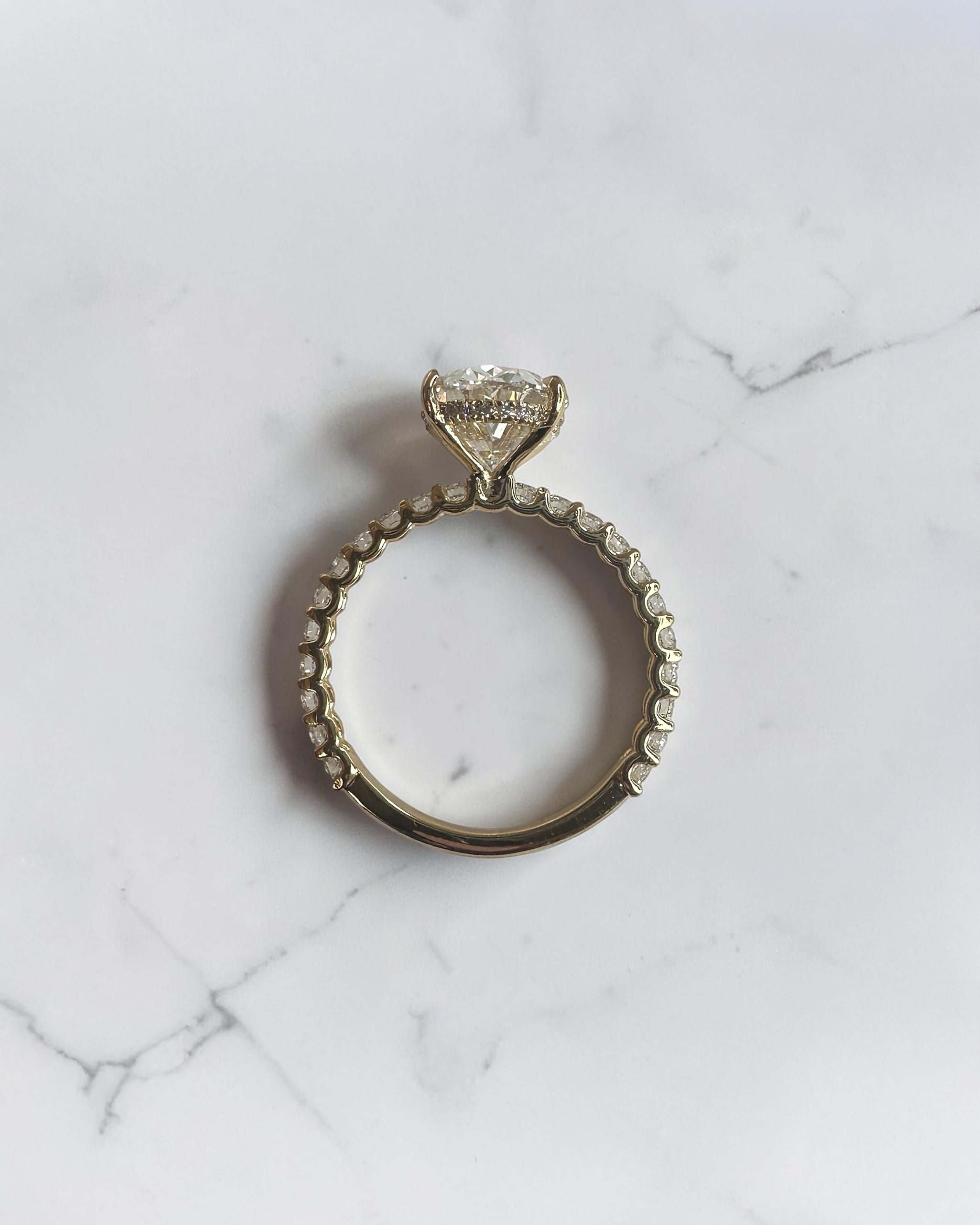 3.50ct oval cut lab grown diamond engagement ring with U prong floating setting and diamond set shoulders in yellow gold
