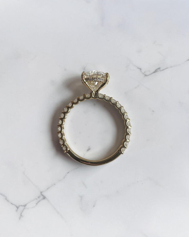 3.50ct oval cut lab grown diamond engagement ring with U prong floating setting and diamond set shoulders in yellow gold
