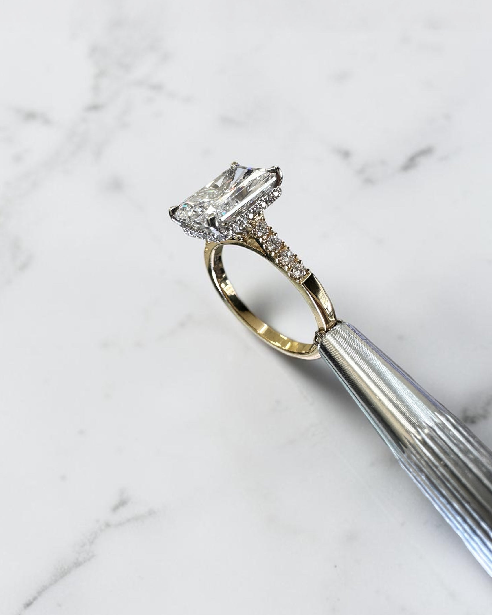 3ct radiant cut lab grown diamond engagement ring with partial pavé band, cathedral setting, hidden halo and two tone yellow gold band