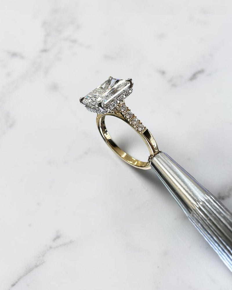 3ct radiant cut lab grown diamond engagement ring with partial pavé band, cathedral setting, hidden halo and two tone yellow gold band