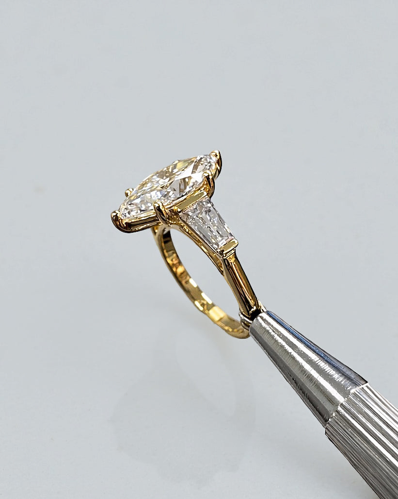 Side profile of a 3 carat marquise diamond ring showing the trilogy baguette setting.