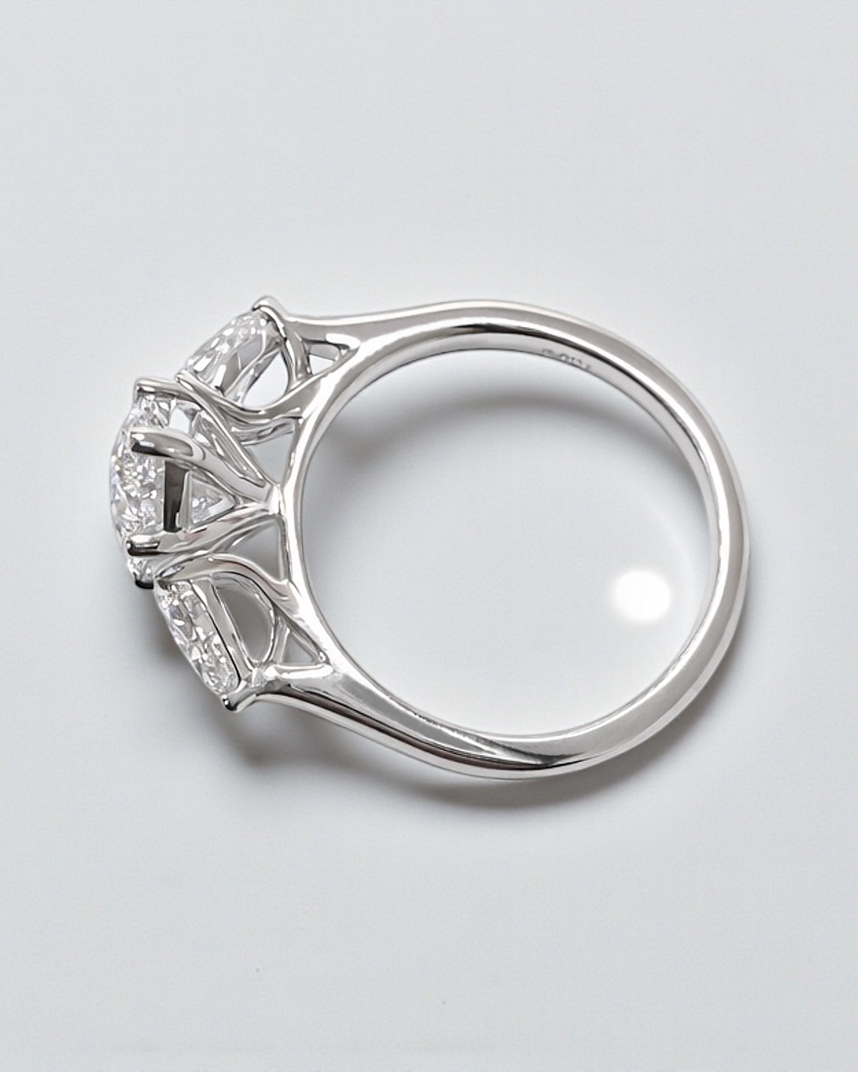 Side profile of a 3 carat marquise diamond engagement ring in a trilogy setting.