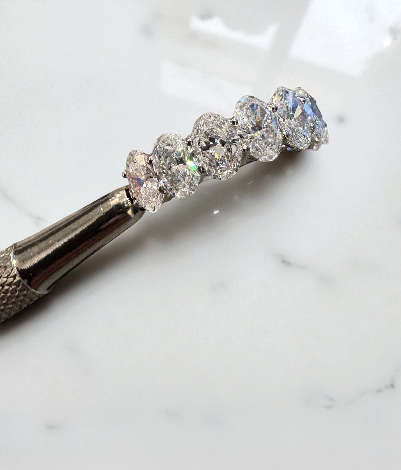 Close-up detail of the high-quality 3 carat oval diamonds on this elegant engagement style band.