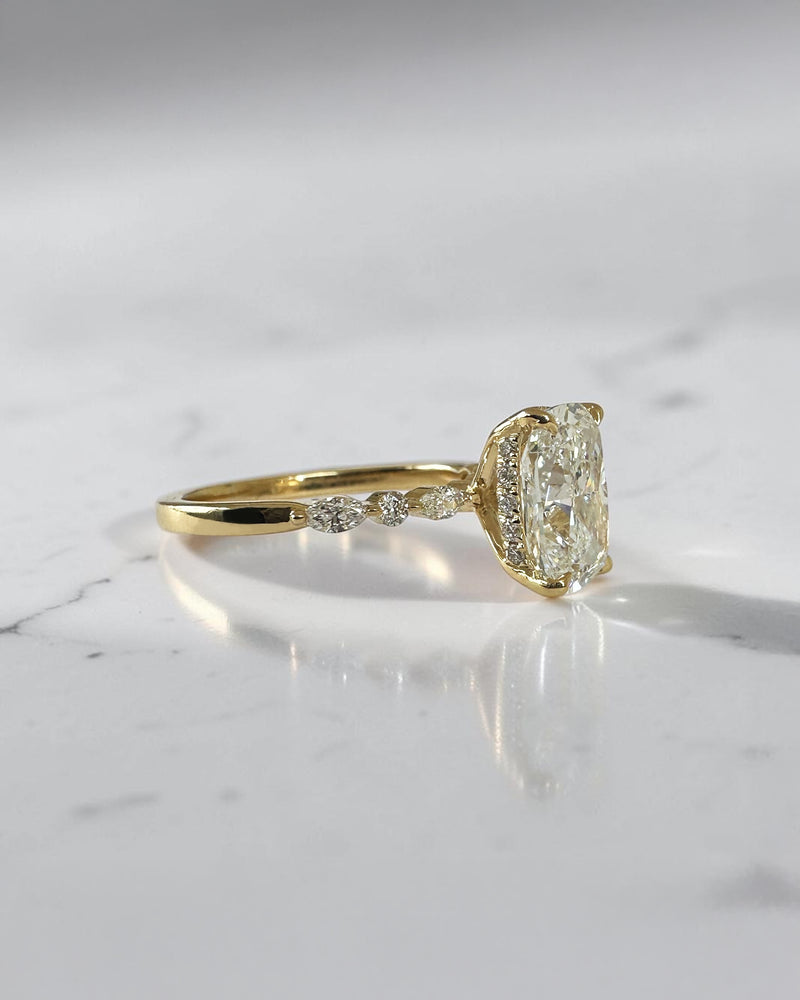 3ct elongated cushion cut lab grown diamond engagement ring featuring a hidden halo, floating head setting and marquise diamond band in 18kt yellow gold.
