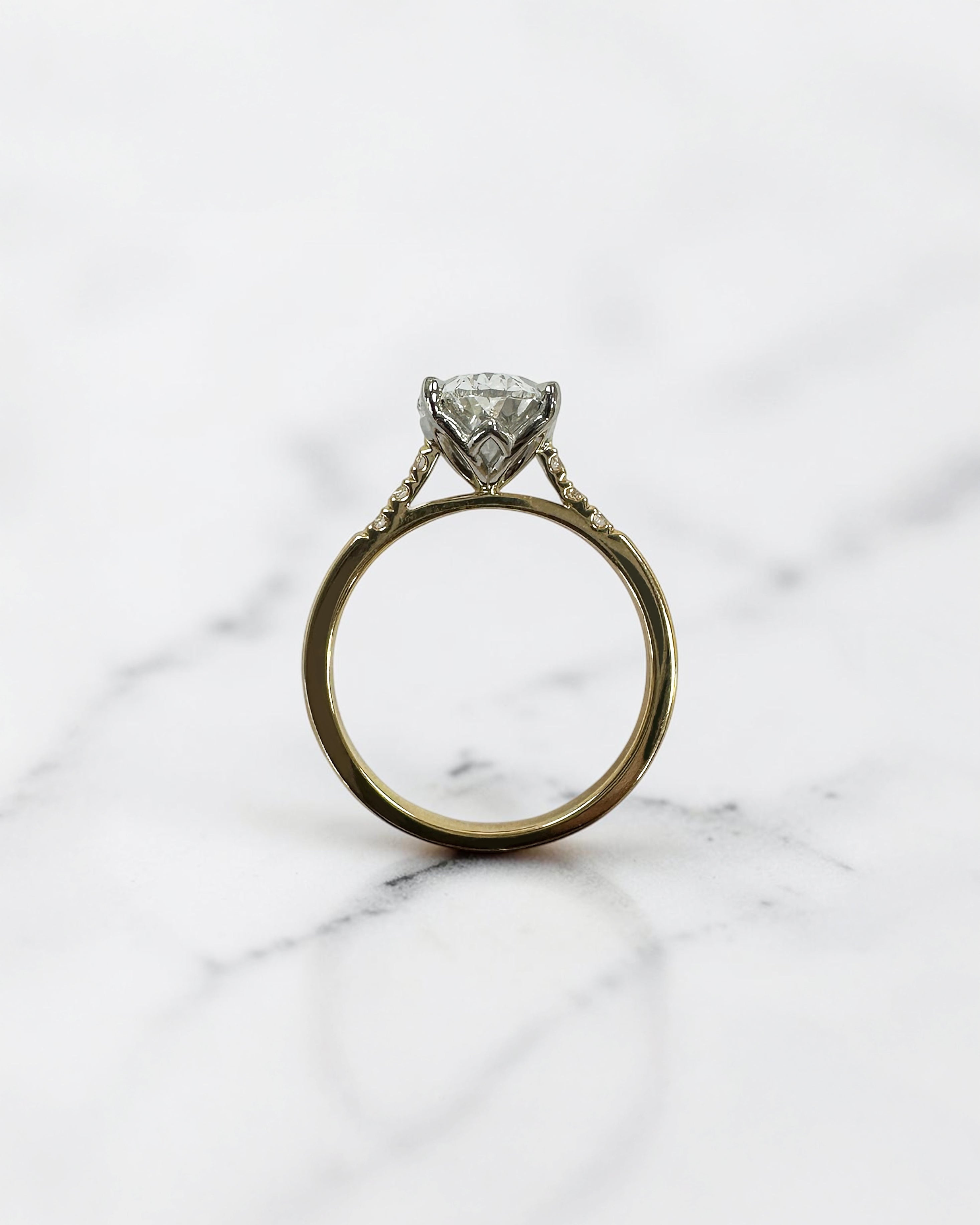 3ct oval cut lab grown diamond engagement ring with a cathedral setting, partial pavé diamond band and diamond wrap around hidden halo. Handmade in London and available in platinum or 18kt yellow gold.
