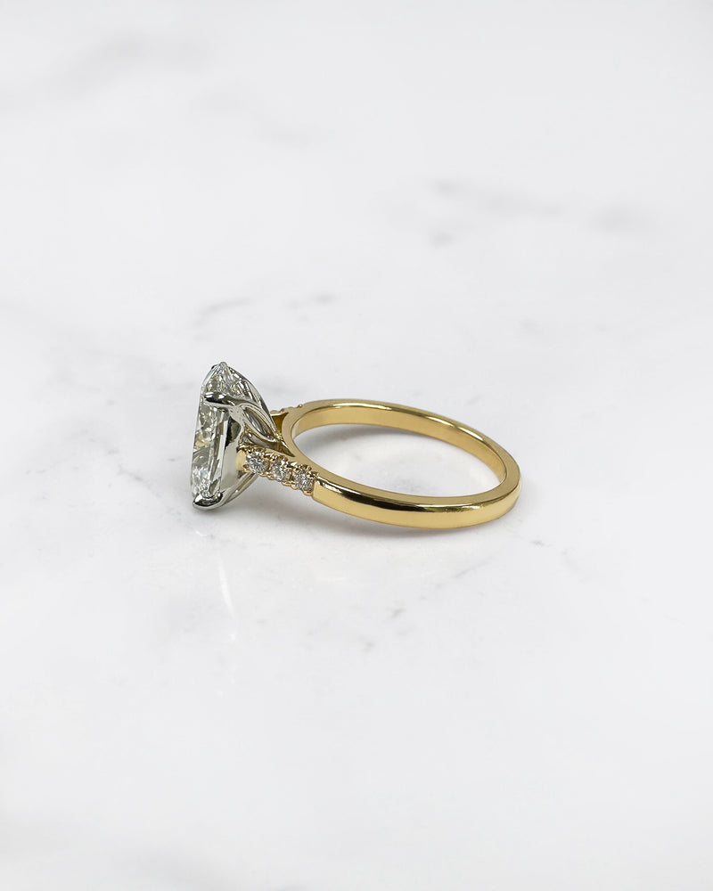 3ct oval cut lab grown diamond engagement ring with a cathedral setting, partial pavé diamond band and diamond wrap around hidden halo. Handmade in London and available in platinum or 18kt yellow gold.
