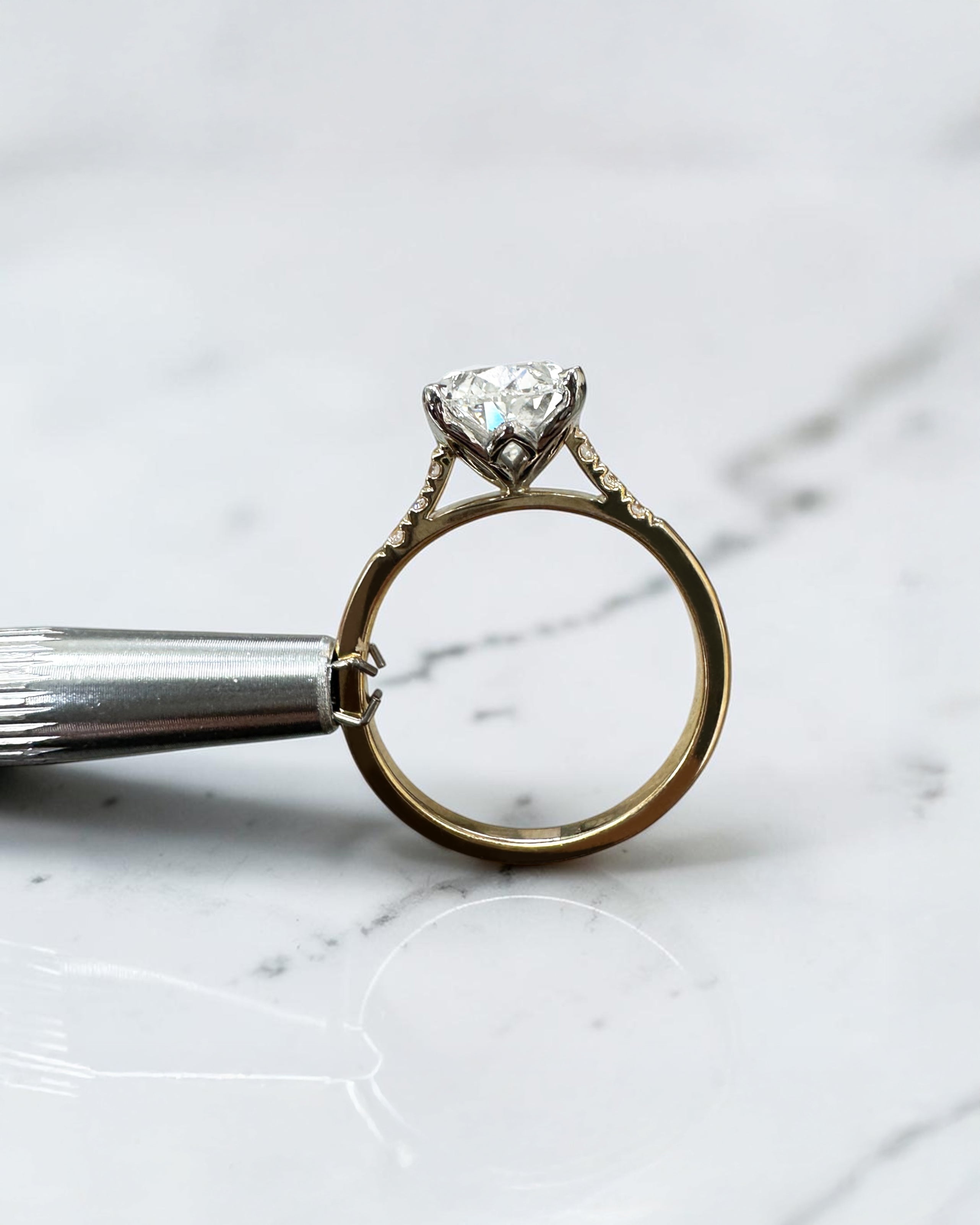 3ct oval cut lab grown diamond engagement ring with a cathedral setting, partial pavé diamond band and diamond wrap around hidden halo. Handmade in London and available in platinum or 18kt yellow gold.
