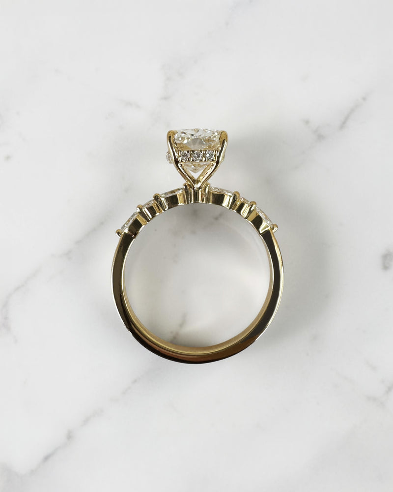 3ct elongated cushion cut lab grown diamond engagement ring featuring a hidden halo, floating head setting and marquise diamond band in 18kt yellow gold.
