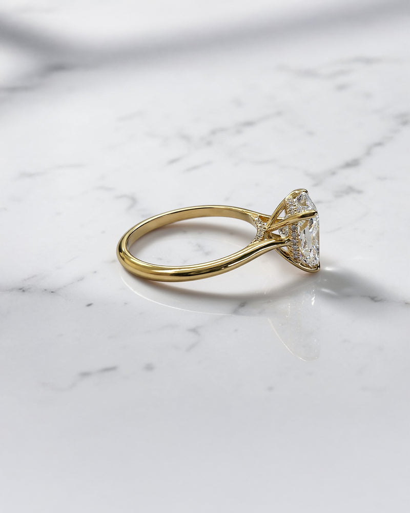 3ct elongated cushion cut lab grown diamond engagement ring with hidden halo and diamond bridge in yellow gold handcrafted in London UK by Layla Diamonds