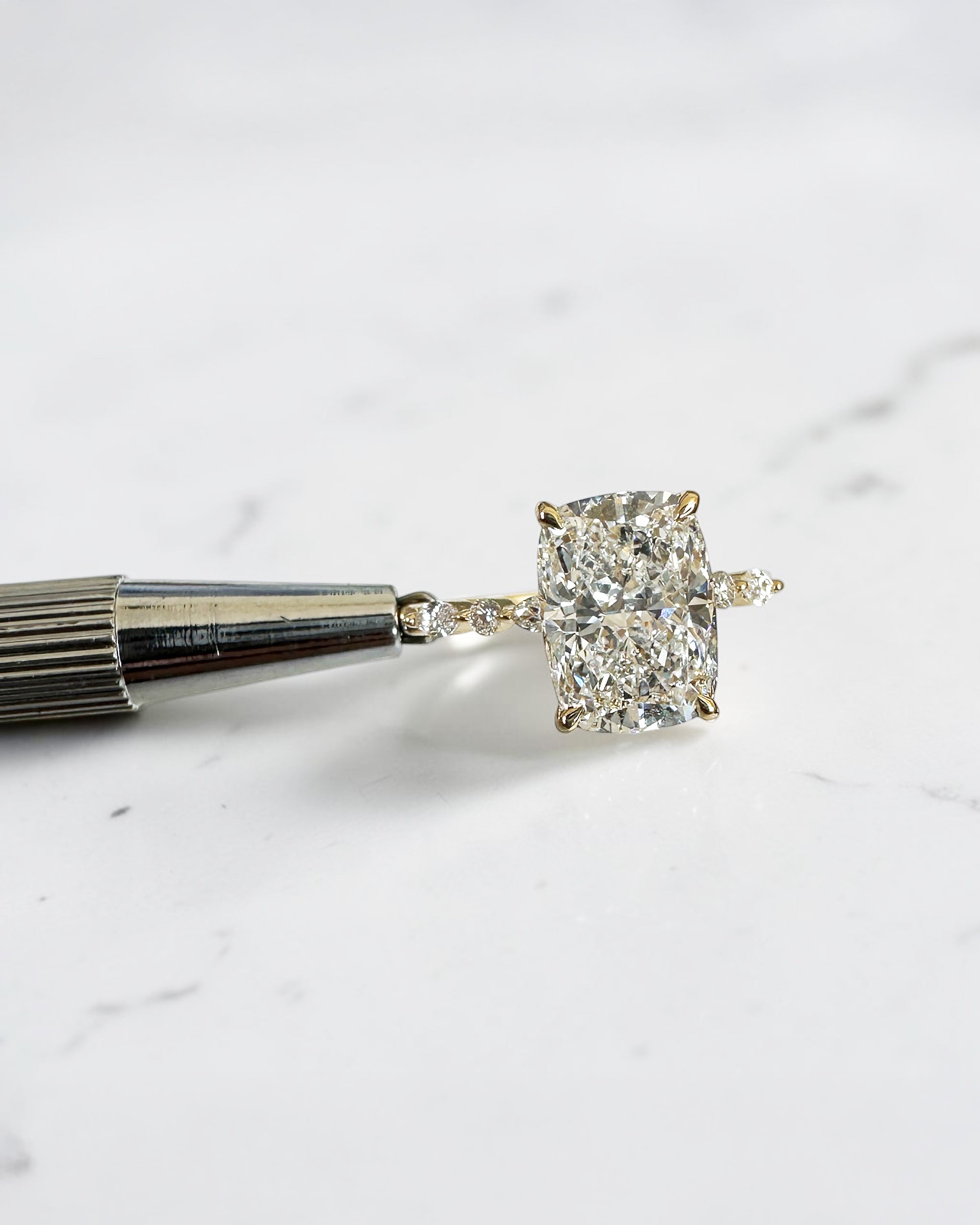 3ct elongated cushion cut lab grown diamond engagement ring with hidden halo, floating head setting and marquise and round diamond band in yellow gold, handmade in London.

