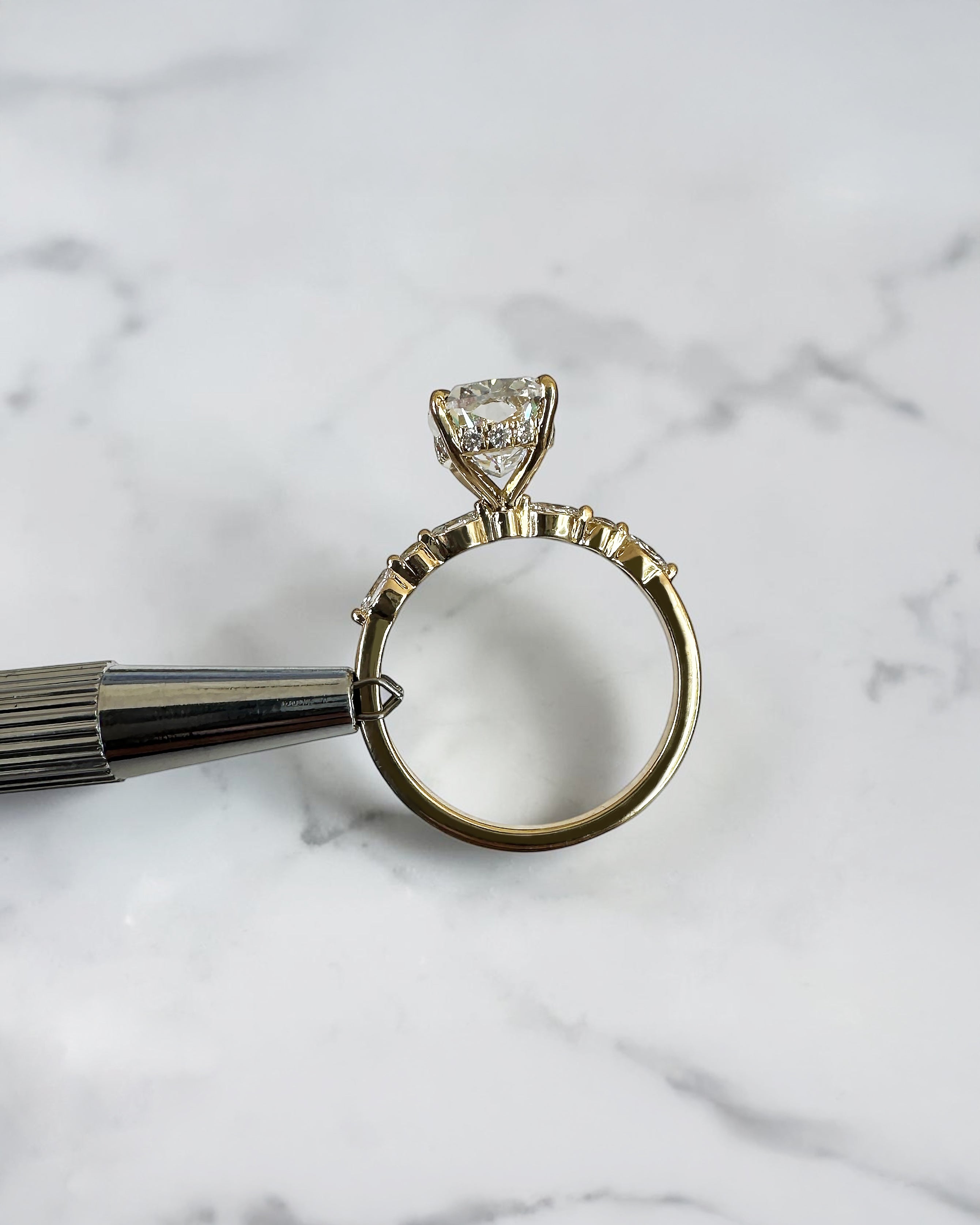 3ct elongated cushion cut lab grown diamond engagement ring with hidden halo, floating head setting and marquise and round diamond band in yellow gold, handmade in London.
