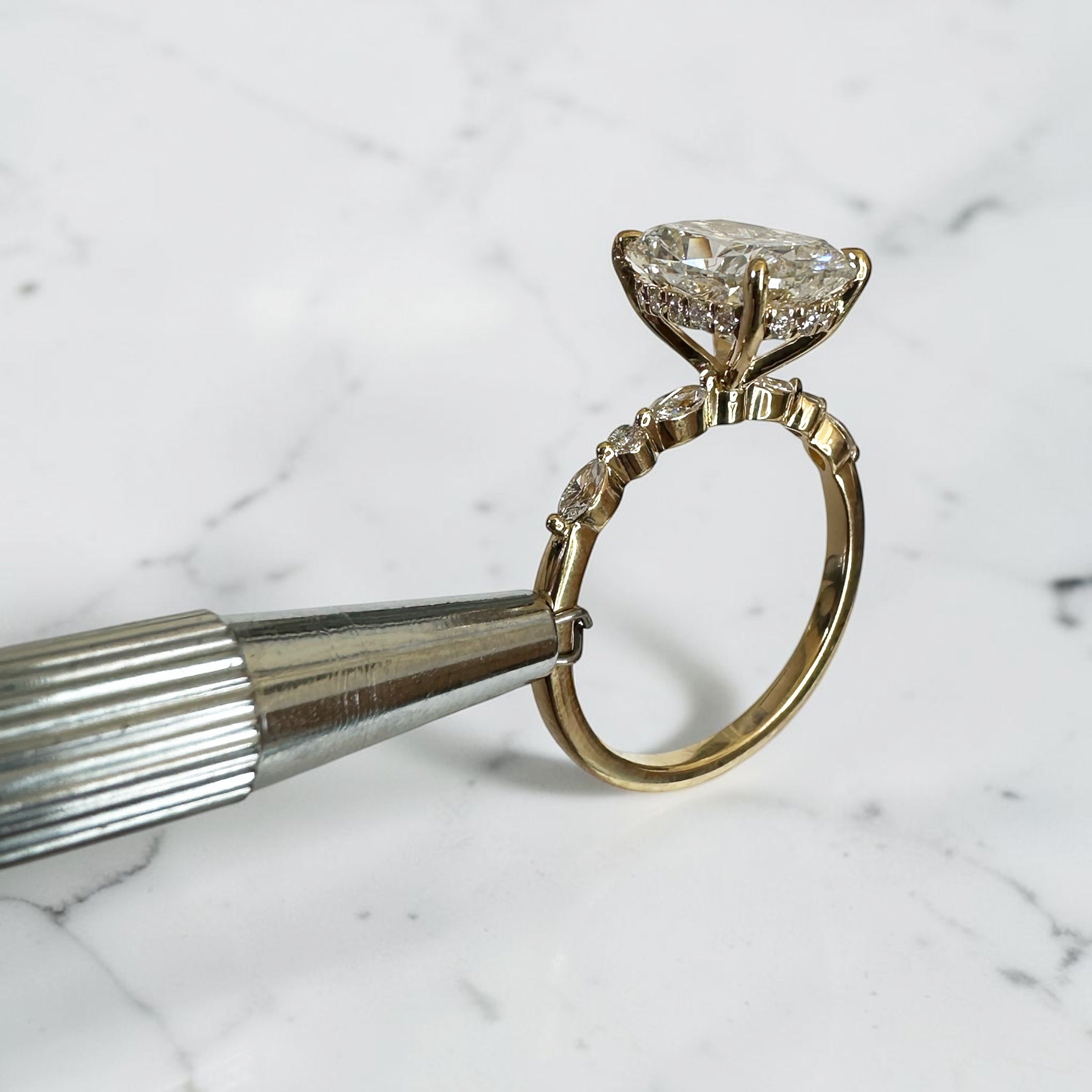 3ct elongated cushion cut lab grown diamond engagement ring with hidden halo, floating head setting and marquise and round diamond band in yellow gold, handmade in London.
