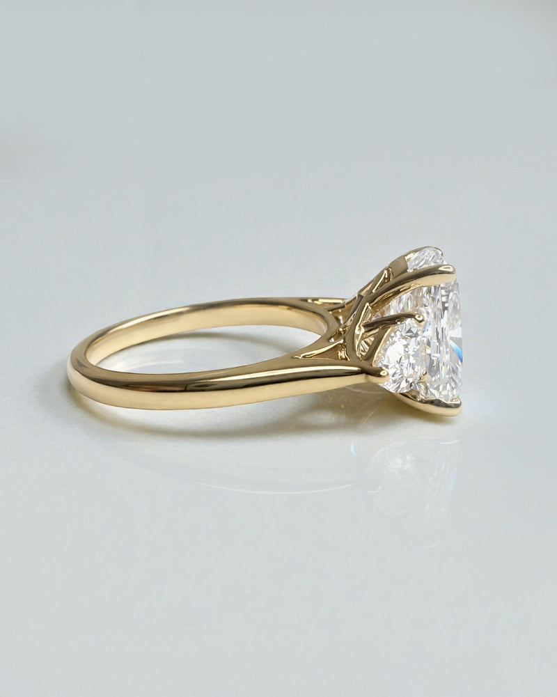 Cushion cut lab grown diamond trilogy engagement ring with pear side stones