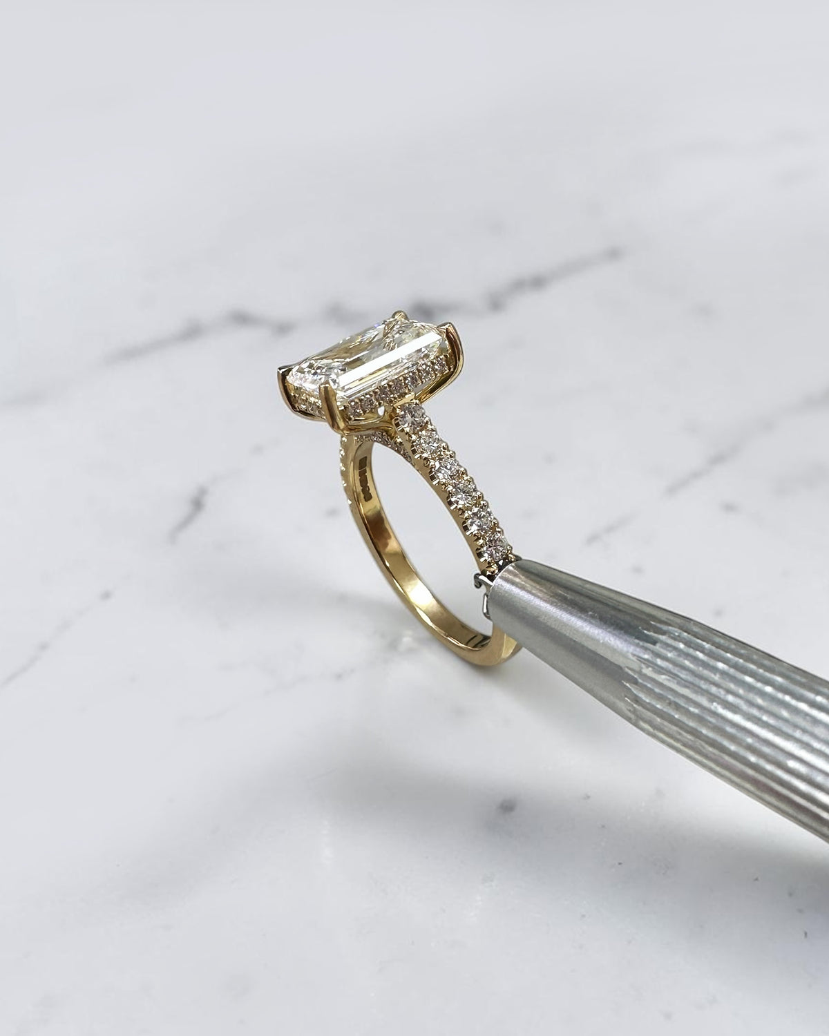 3ct emerald cut lab grown diamond cathedral engagement ring with diamond shoulders, hidden halo and diamond bridge