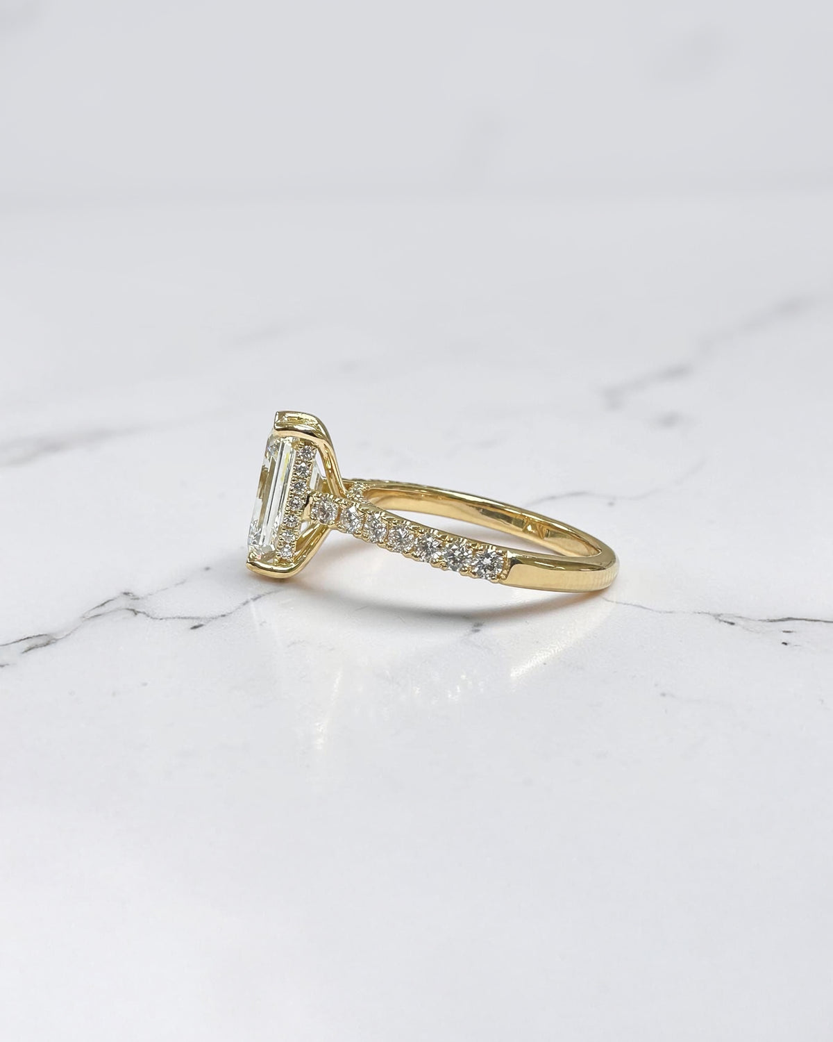 3ct emerald cut lab grown diamond cathedral engagement ring with diamond shoulders, hidden halo and diamond bridge