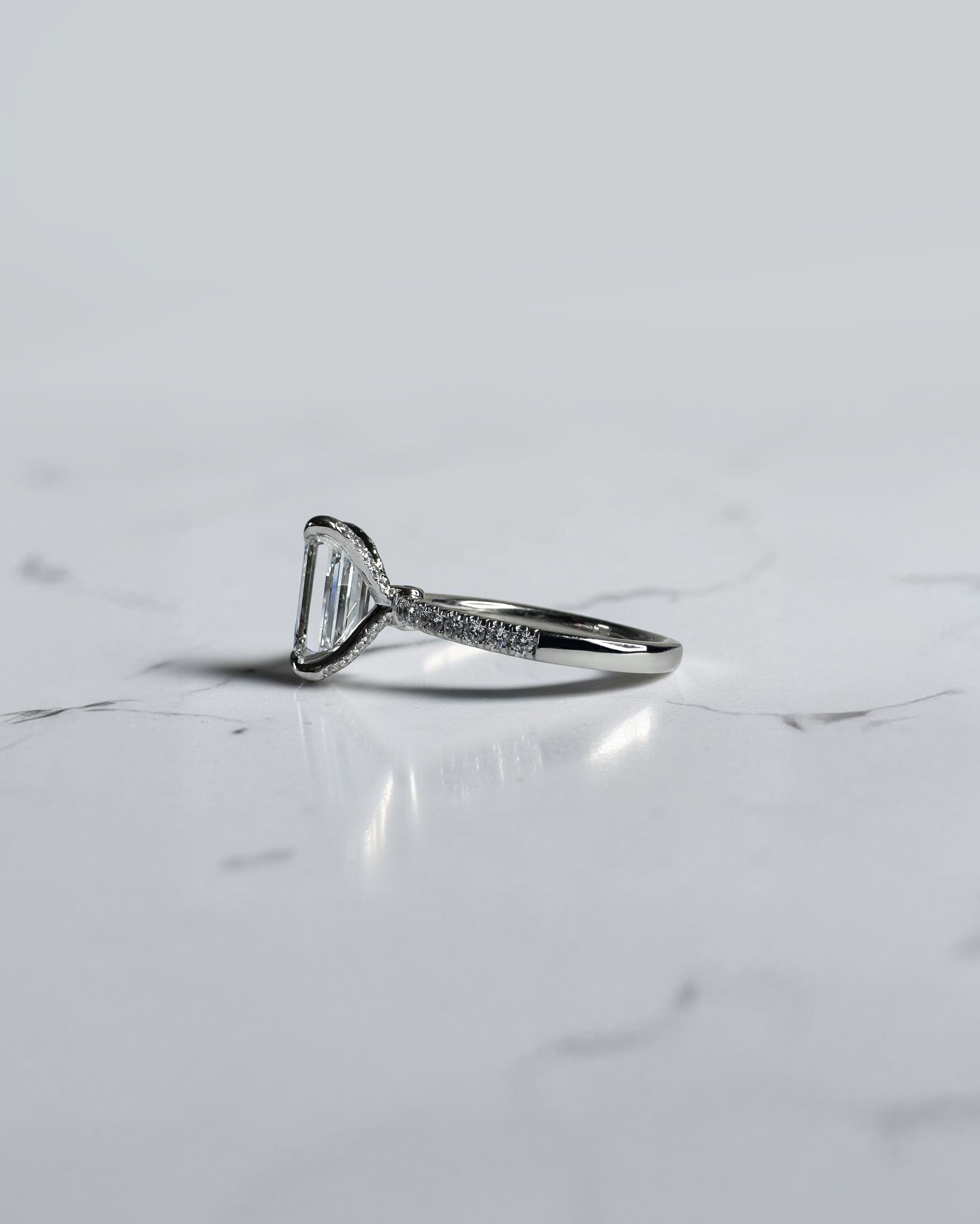 3ct emerald cut diamond ring with open diamond prongs setting and diamond shoulders, handcrafted in London