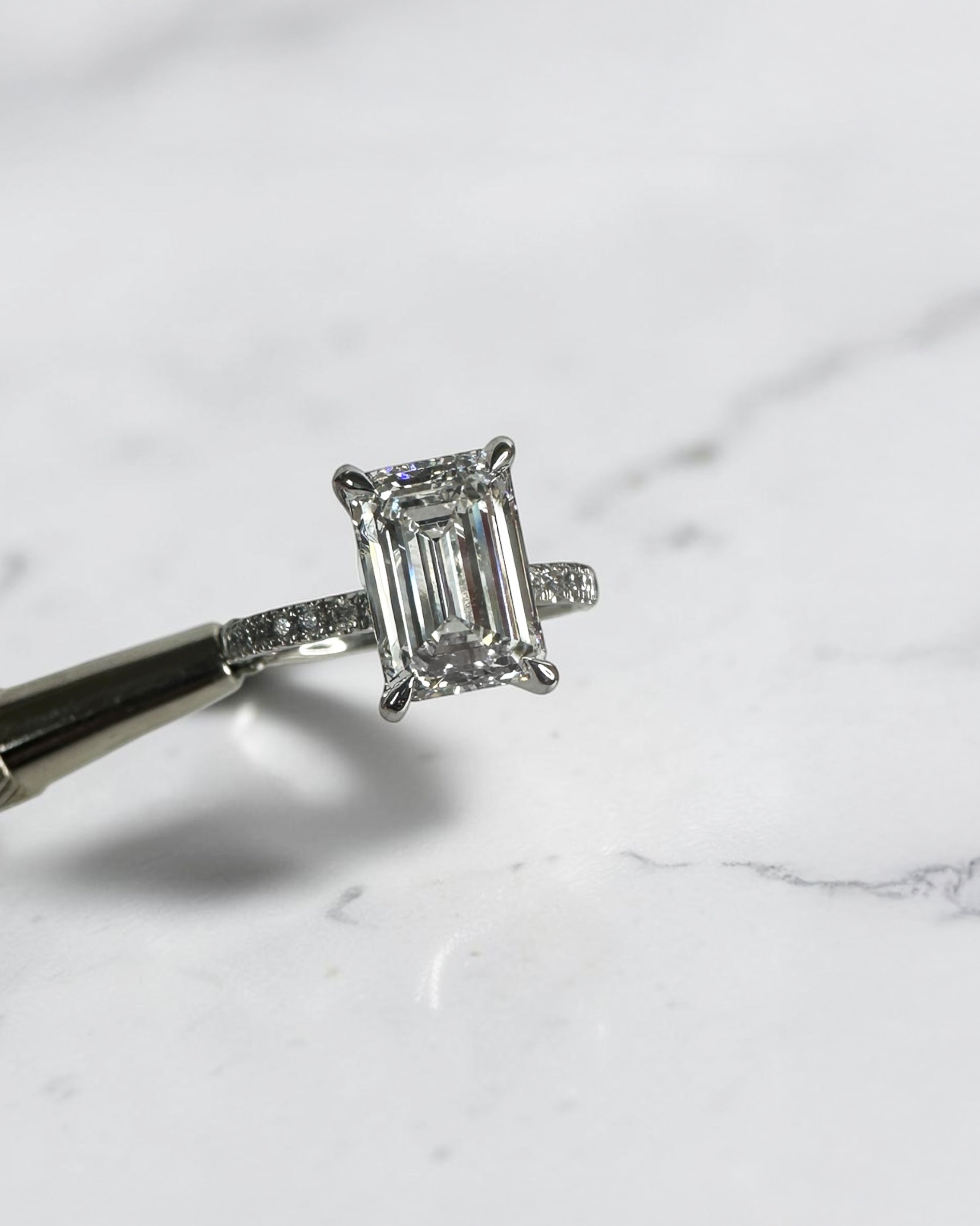 3ct emerald cut diamond engagement ring with open diamond prongs and pavé diamond band in platinum, total 3.38ct
