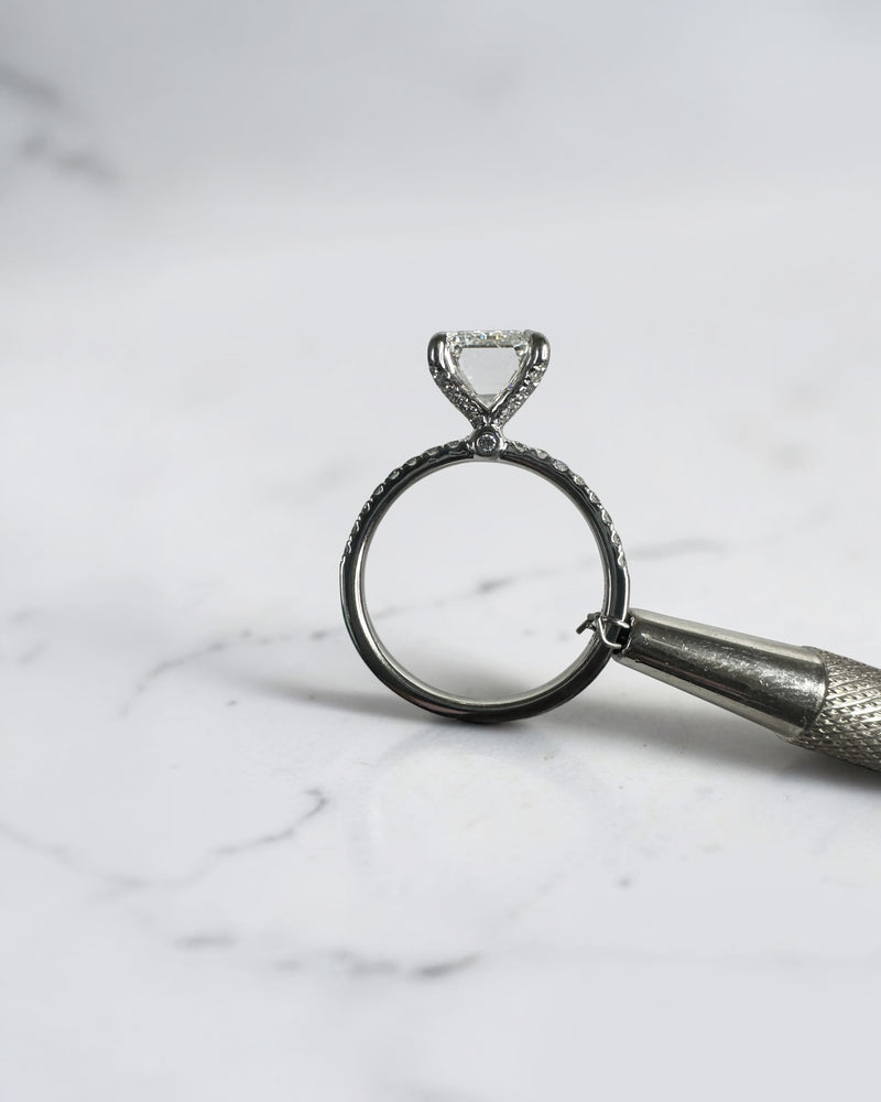3ct emerald cut diamond engagement ring with open diamond prongs and pavé diamond band in platinum, total 3.38ct
