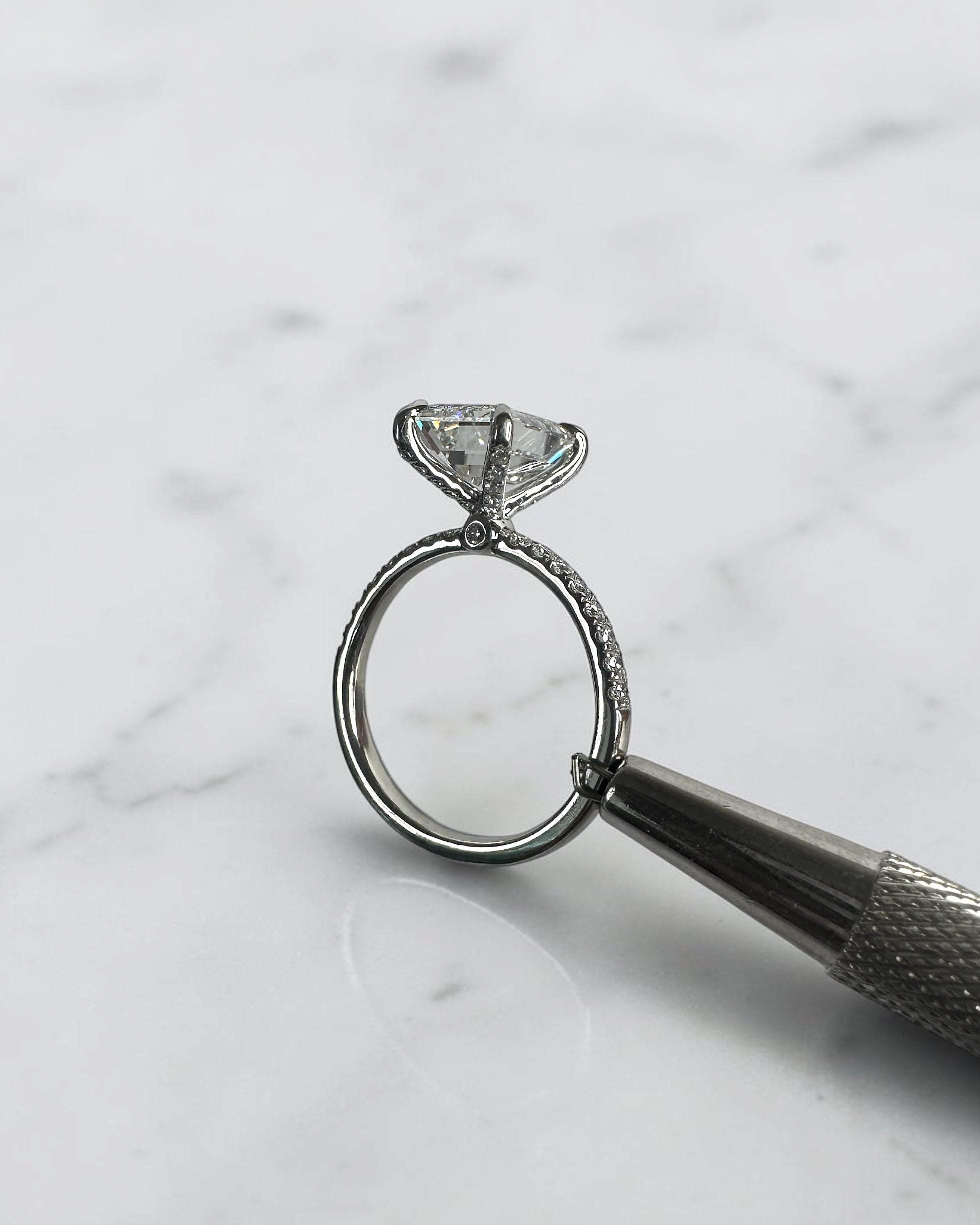 3ct emerald cut diamond ring with open diamond prong setting and diamond shoulders, handcrafted in London