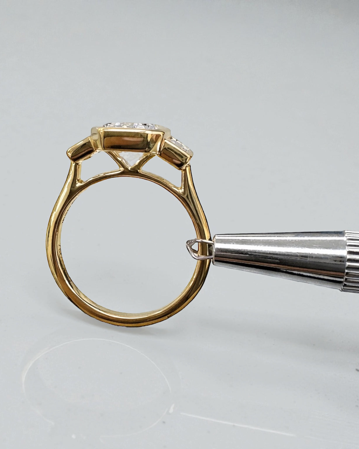 3ct emerald cut lab grown diamond bezel set trilogy engagement ring with tapered baguette side diamonds in 18kt yellow gold