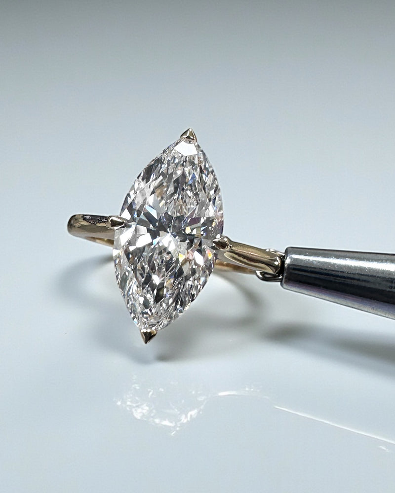 Marquise diamond solitaire ring featuring a hidden halo setting in white gold