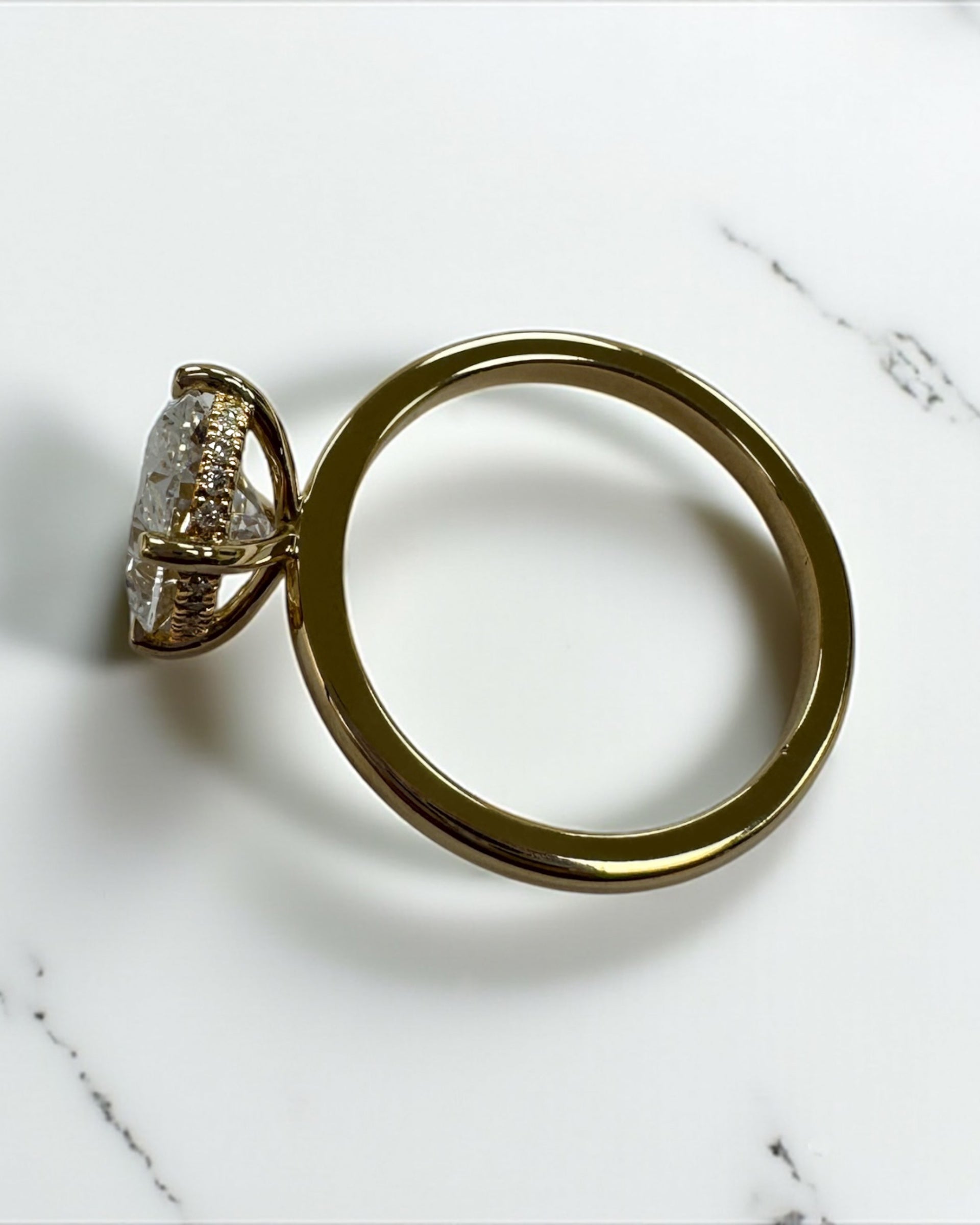 3ct oval cut lab grown diamond floating head engagement ring 18kt yellow gold with hidden halo on a plain soft court band