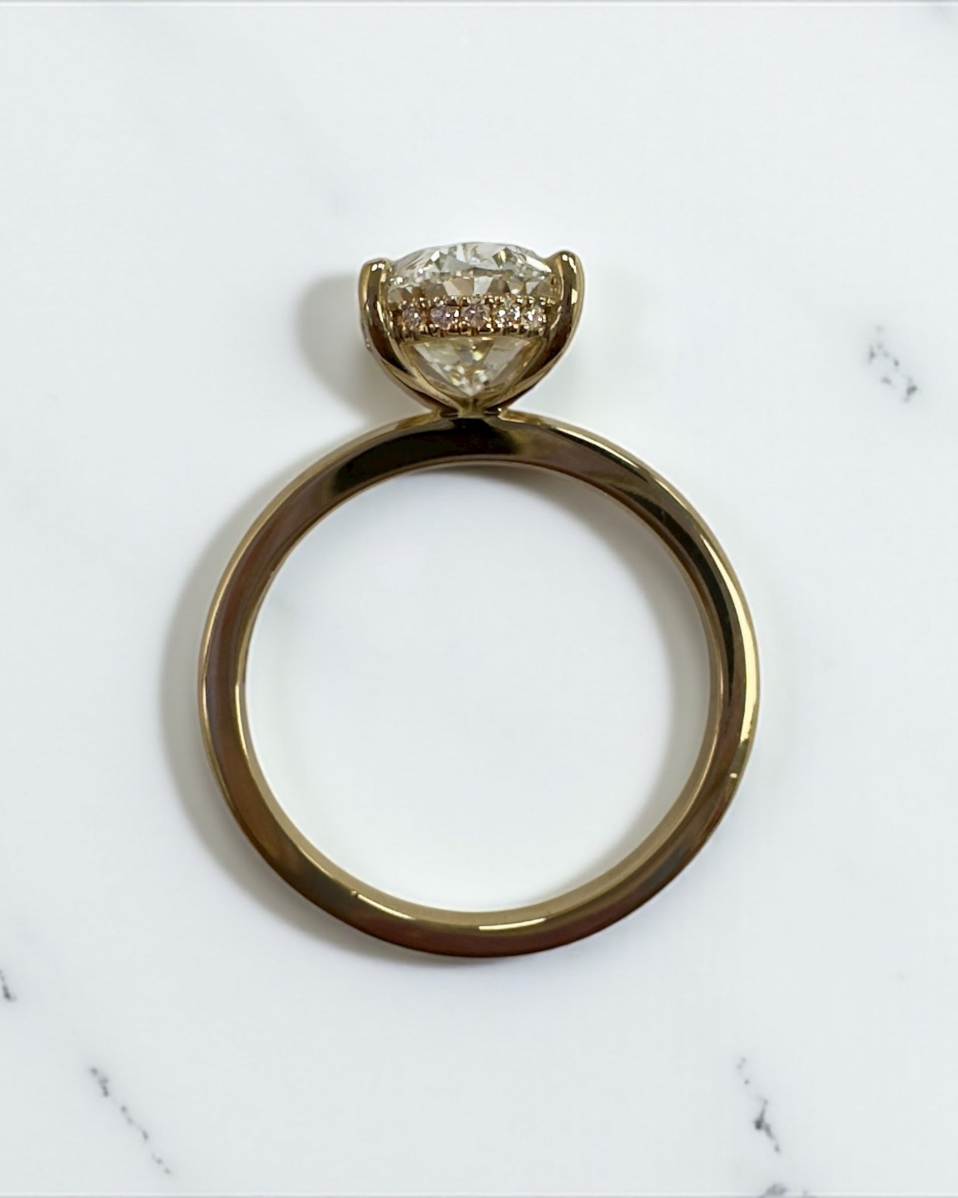 3ct oval cut lab grown diamond floating head engagement ring 18kt yellow gold with hidden halo on a plain soft court band
