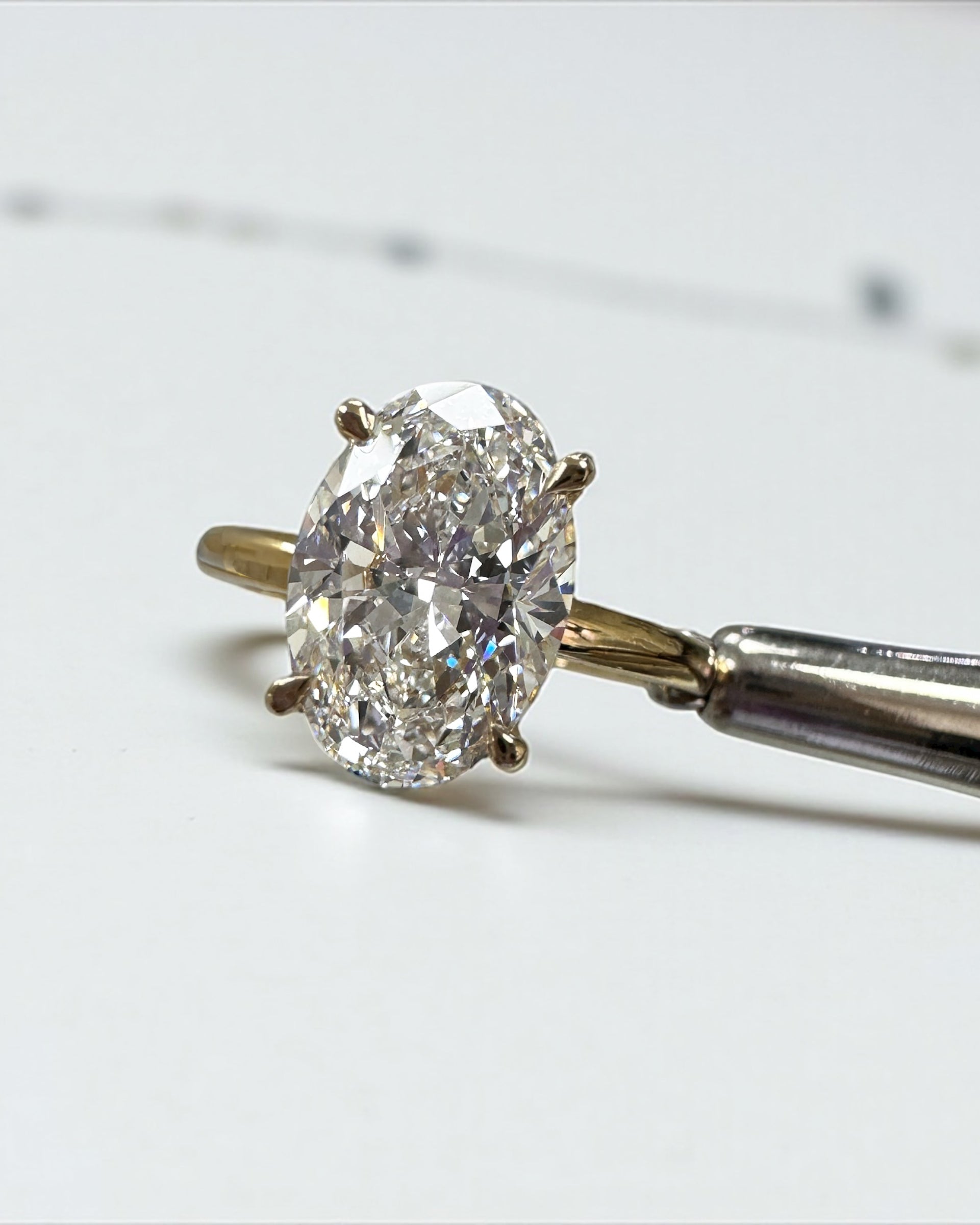3ct oval cut lab grown diamond floating head engagement ring 18kt yellow gold with hidden halo on a plain soft court band