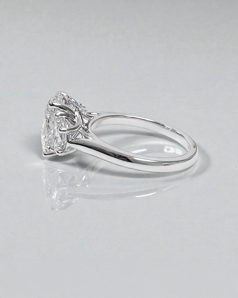 Side view of 3ct oval lab grown diamond ring with half moon side stones and sculpted gallery in white gold
