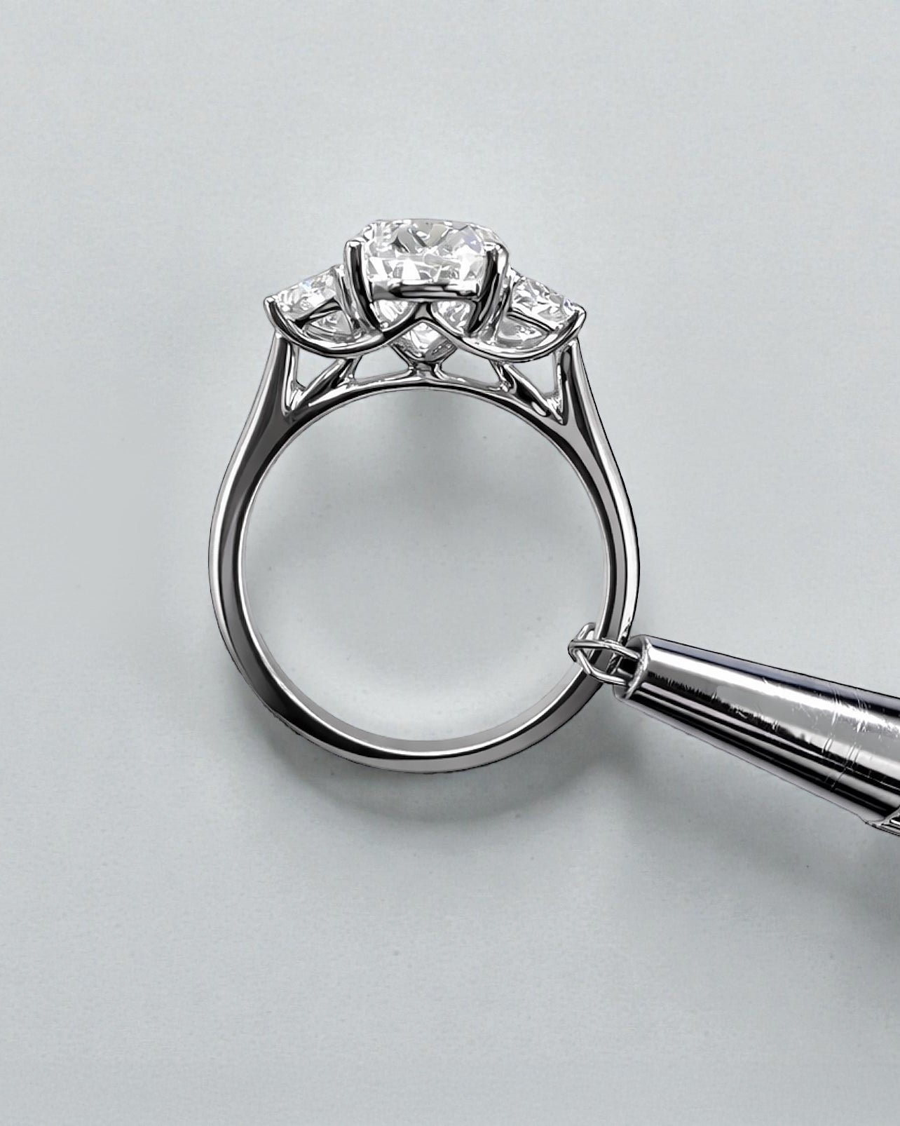 Side view of 3ct oval lab grown diamond ring with half moon side stones and sculpted gallery in white gold