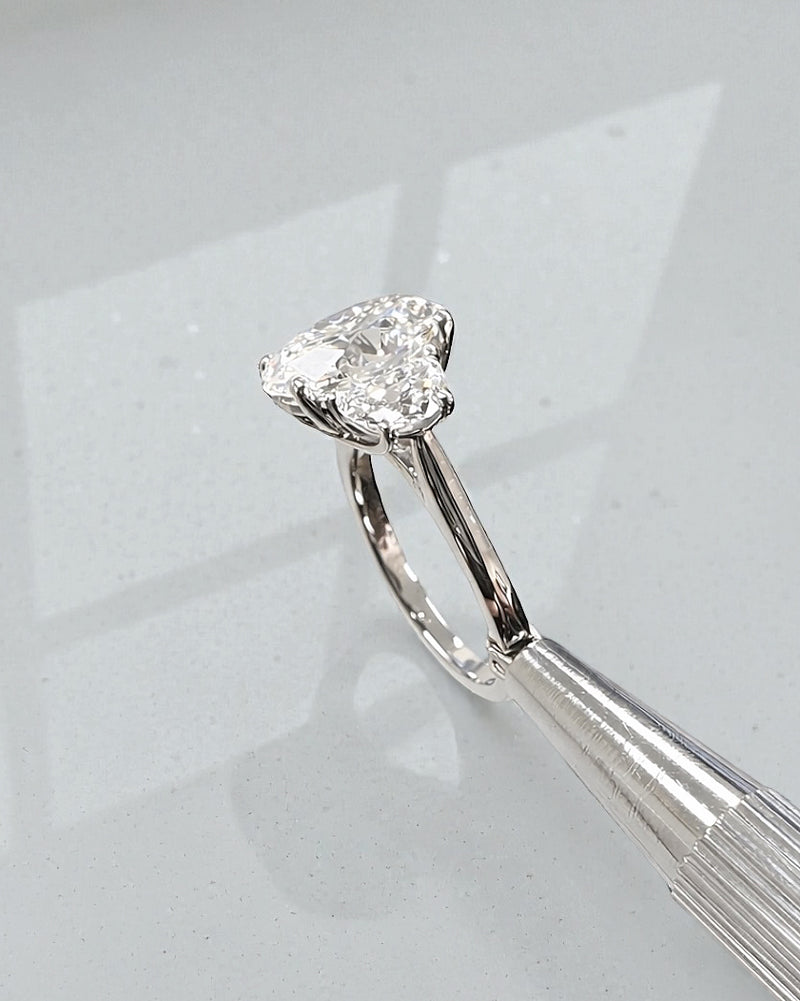 Side view of 3ct oval lab grown diamond ring with half moon side stones and sculpted gallery in platinum
