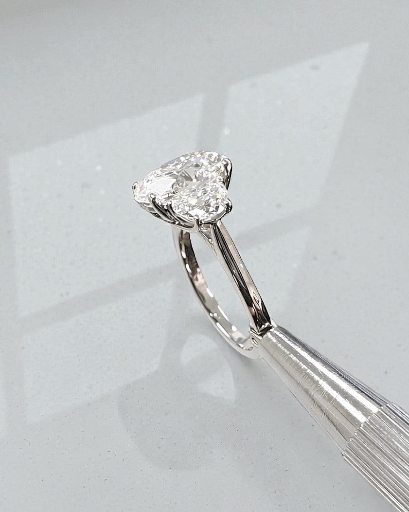 Side view of 3ct oval lab grown diamond ring with half moon side stones and sculpted gallery in platinum
