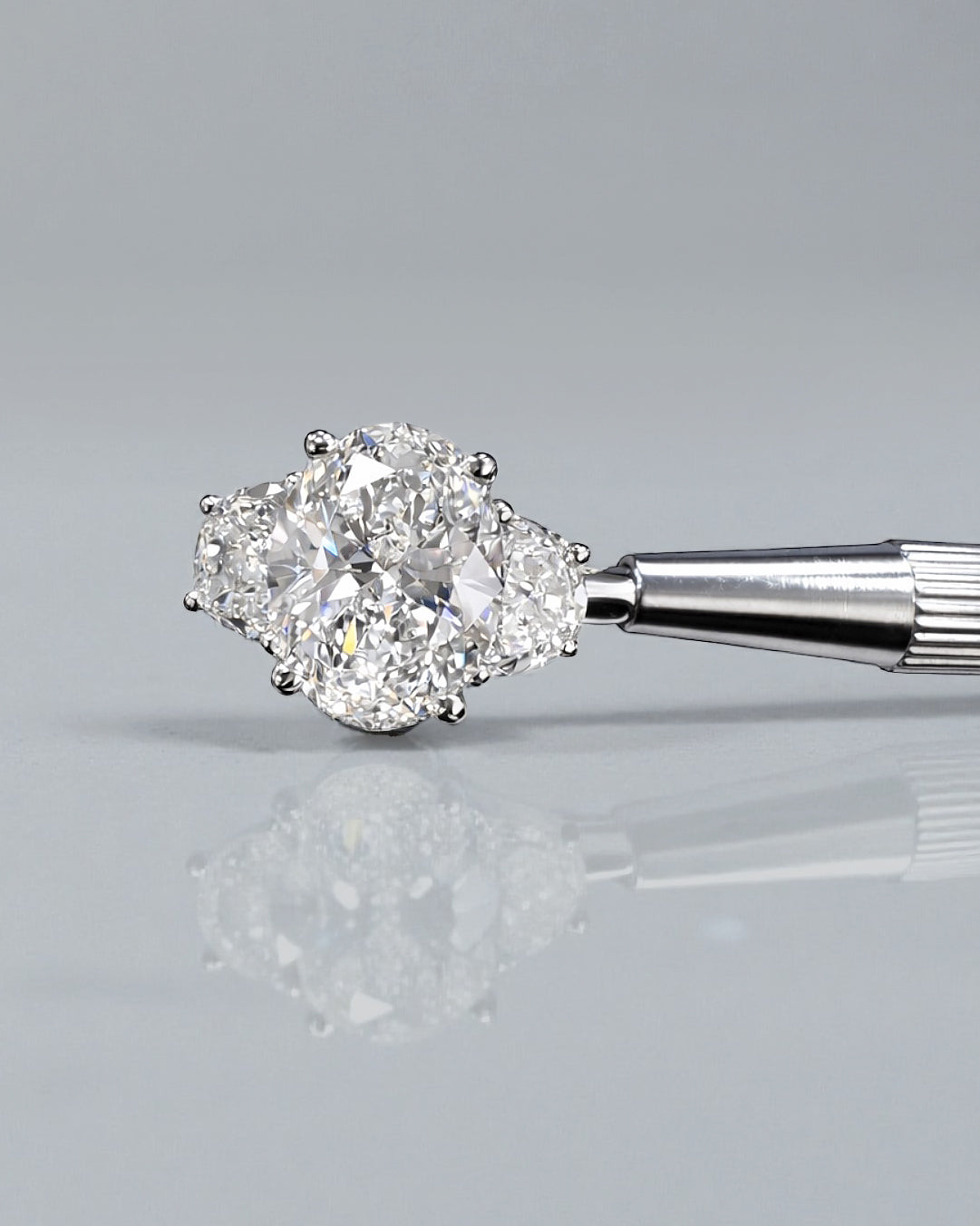 Rear view of oval diamond trilogy ring with half moon side diamonds in polished platinum