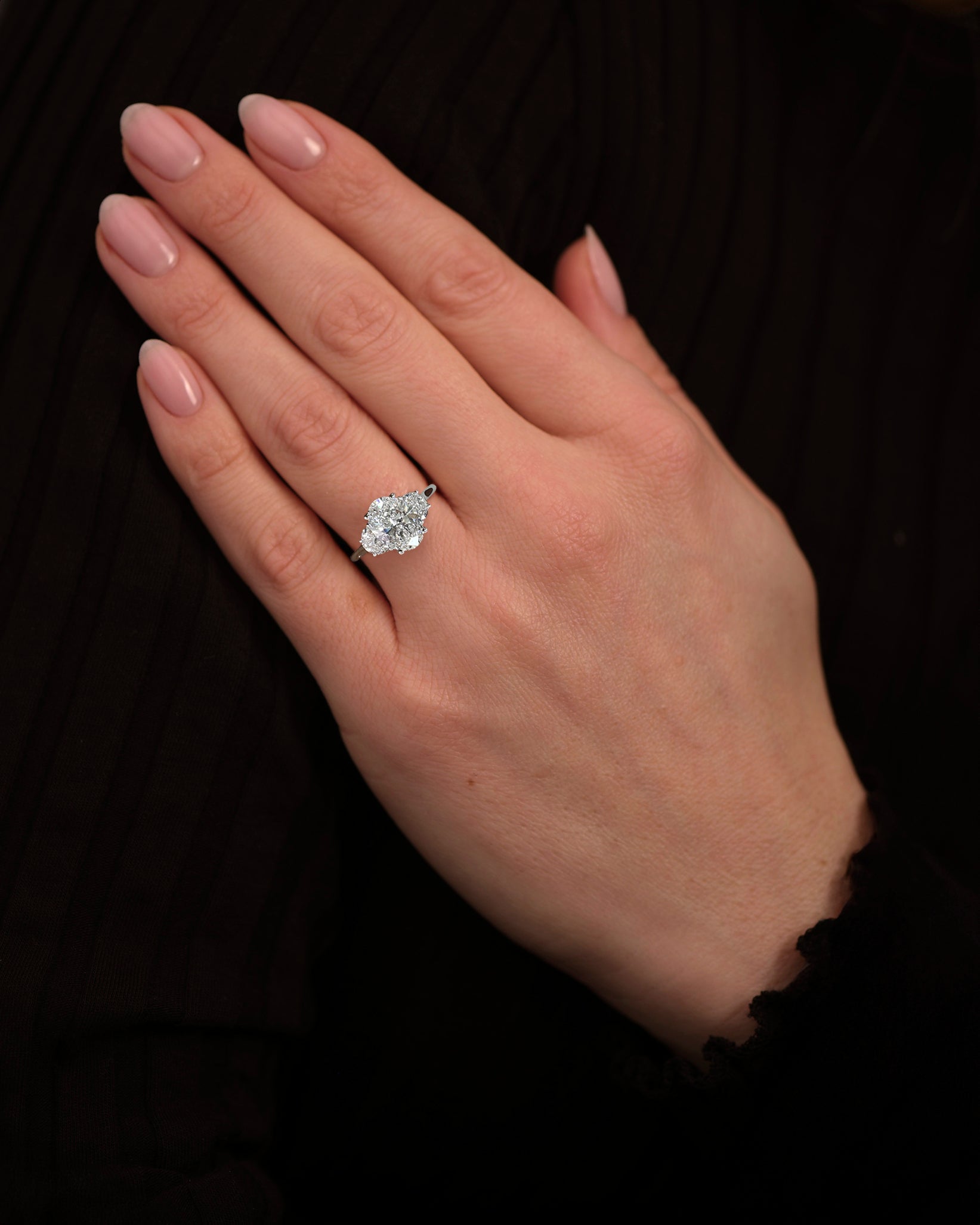 3ct oval cut lab grown diamond trilogy engagement ring with half moon side diamonds in platinum on hand