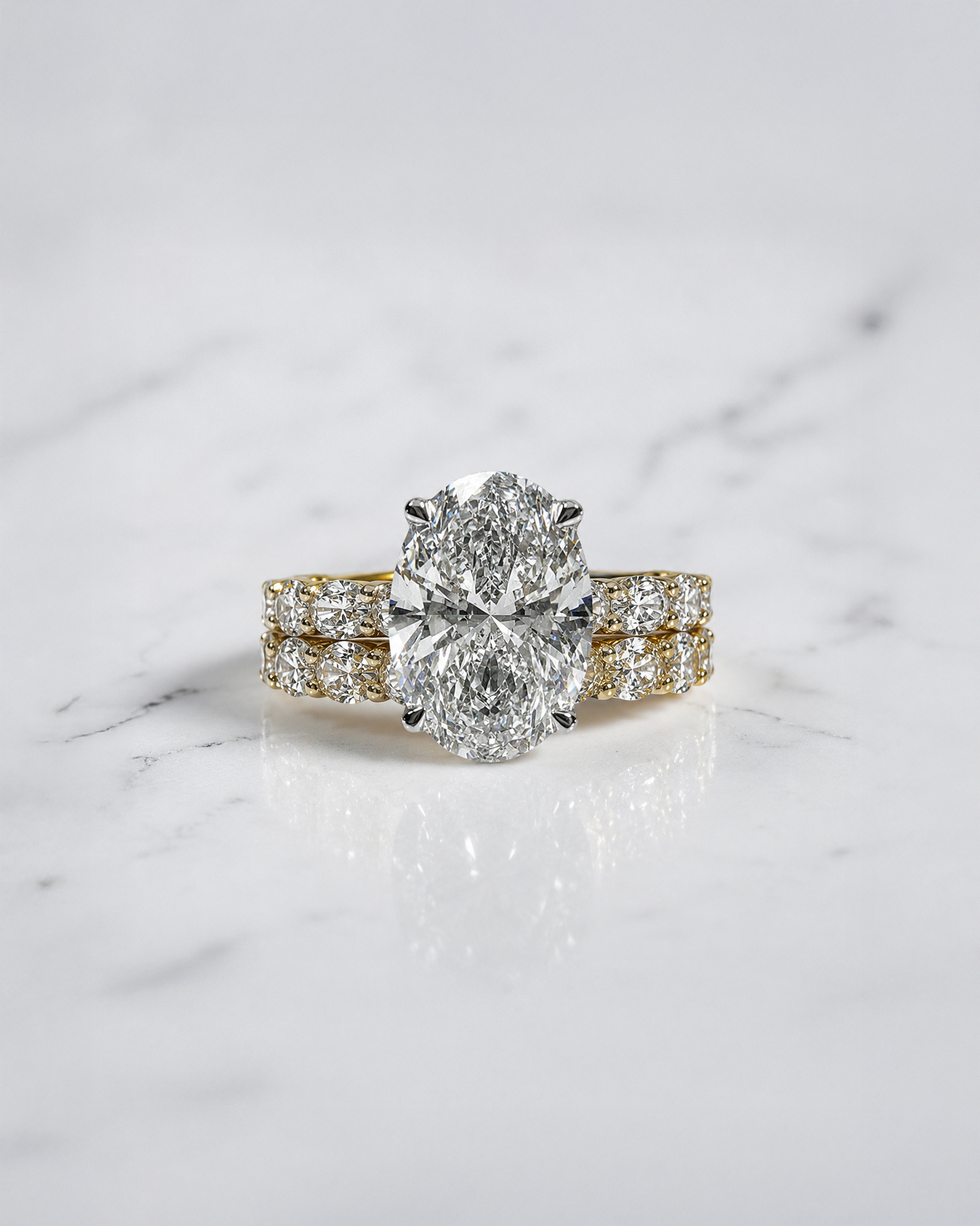 3ct oval cut lab grown diamond hidden halo engagement ring with east west oval diamond band in two tone platinum and 18kt yellow gold.
