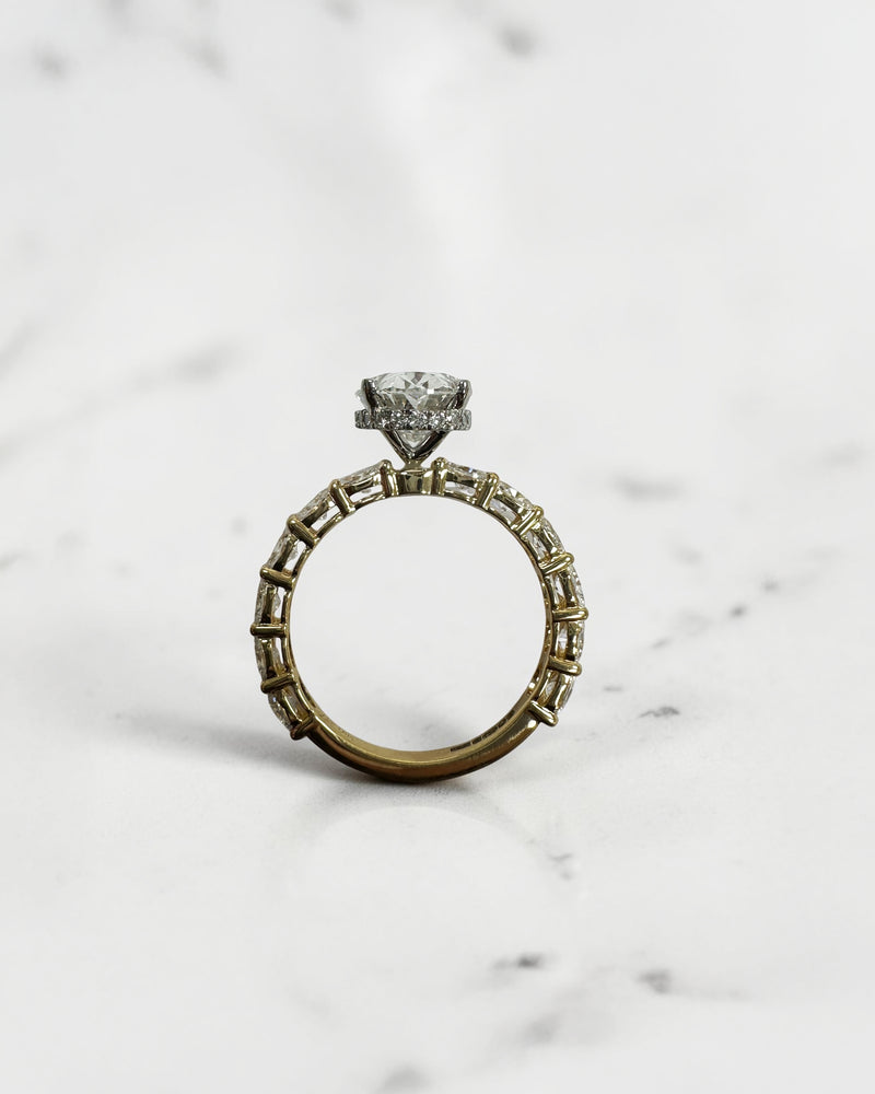 3ct oval cut lab grown diamond hidden halo engagement ring with east west oval diamond band in two tone platinum and 18kt yellow gold.