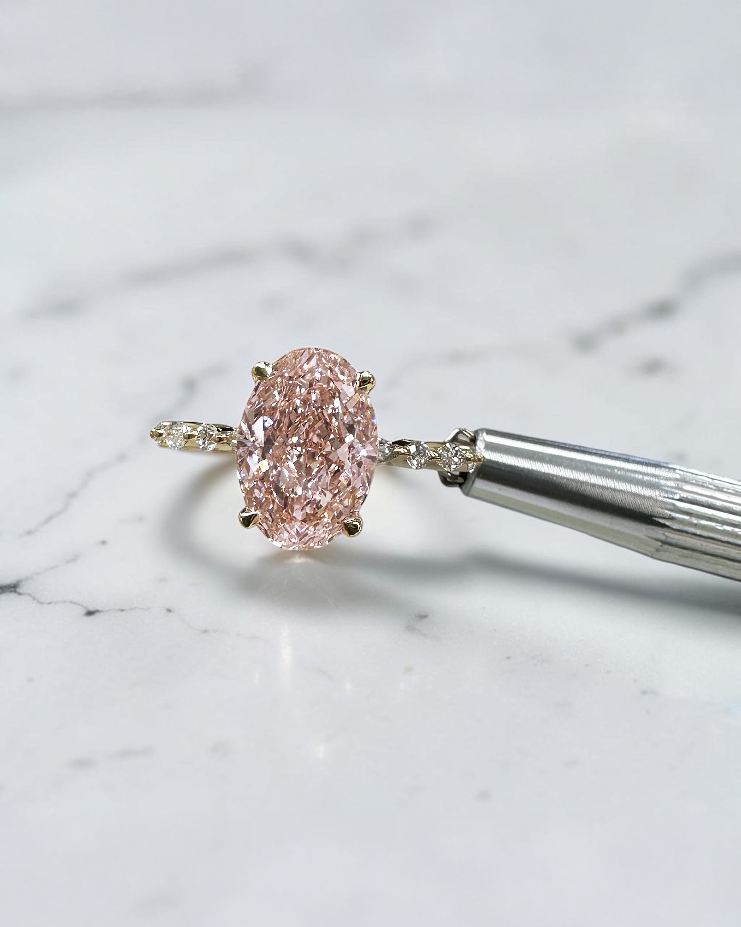 3ct pink oval cut lab grown diamond engagement ring with a floating setting, marquise and round diamond band in 18ct yellow gold, handcrafted in London by Layla Diamonds.