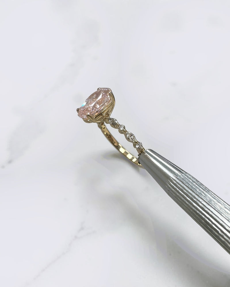 3ct pink oval cut lab grown diamond engagement ring with a floating setting, marquise and round diamond band in 18ct yellow gold, handcrafted in London by Layla Diamonds.